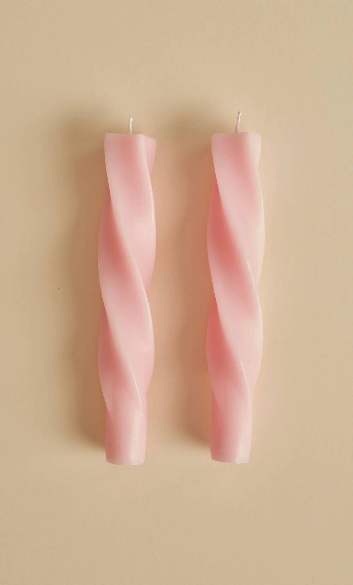 Lex Pott twisted taper candles, wax, pastel pink, minimalist design on beige background