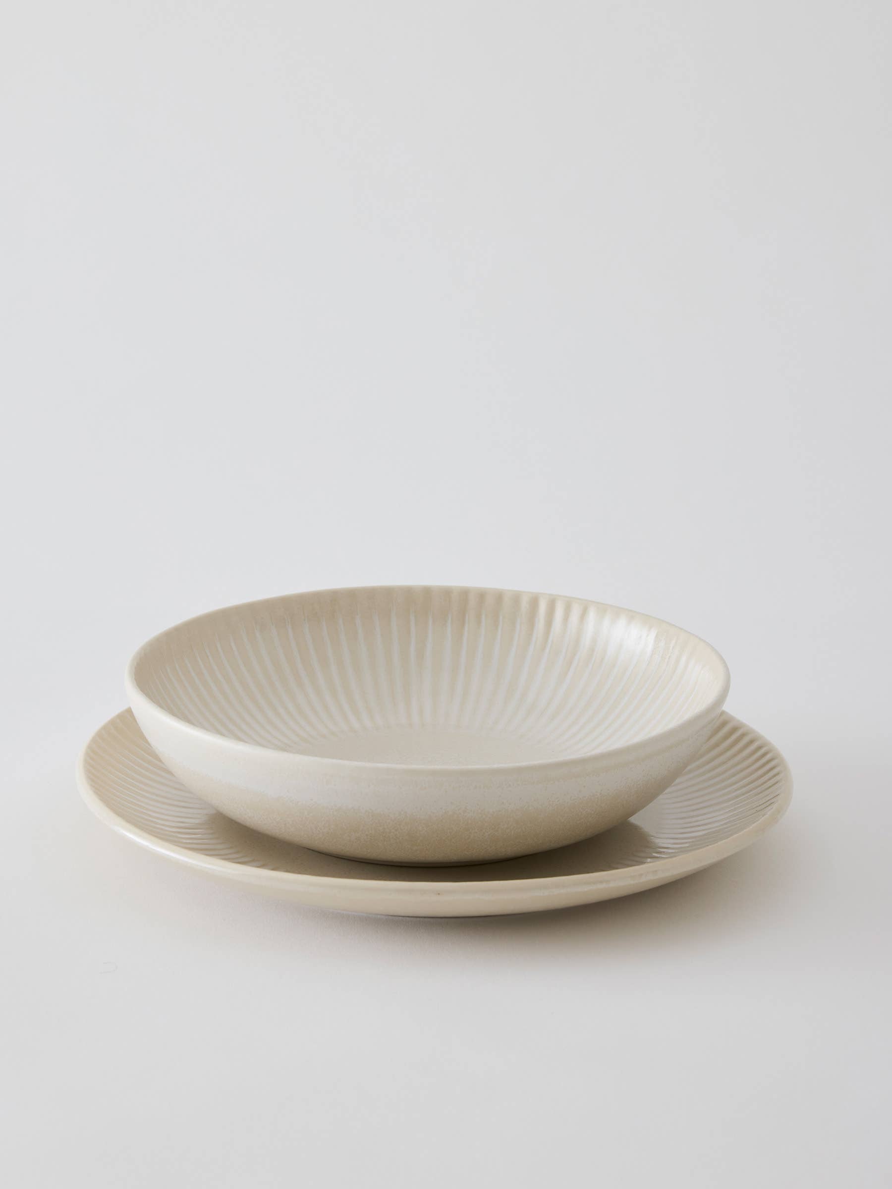 Lucy Burley ceramic bowl, cream with black stripes, handmade pottery on linen cloth