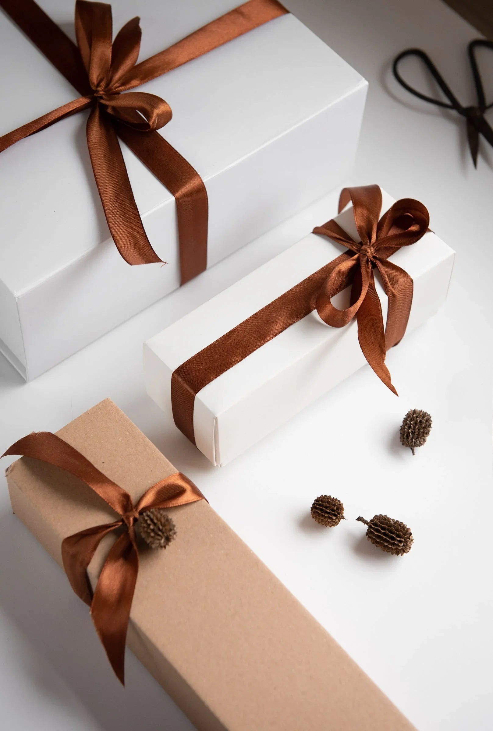Haute Stock premium gift boxes in white and kraft paper with satin brown ribbons, festive setting