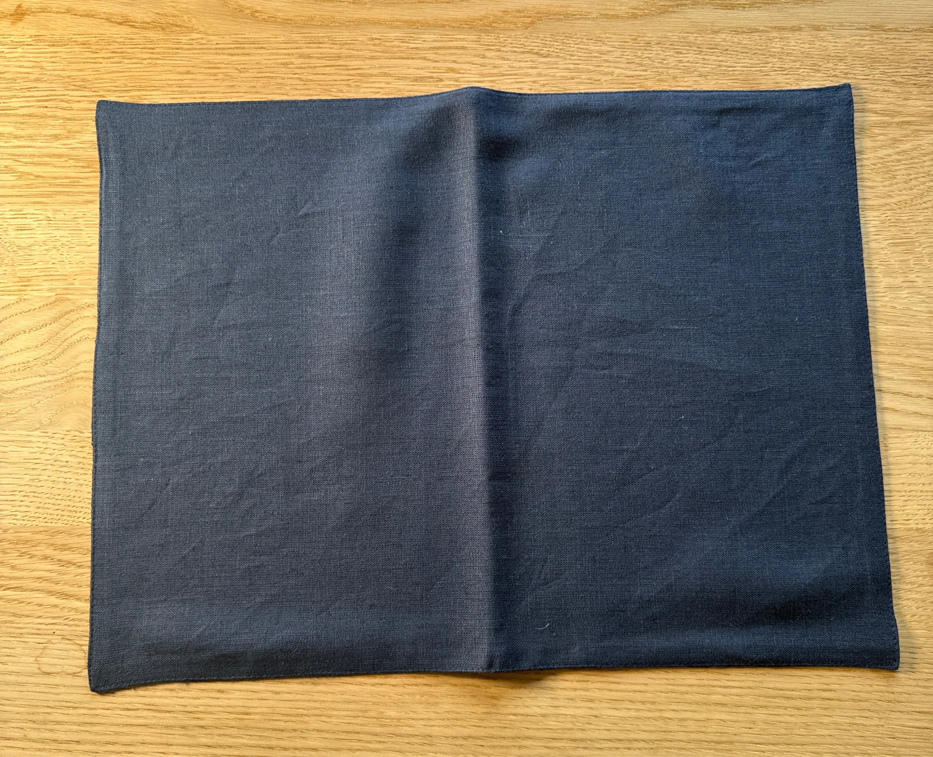 MagicLinen dark grey linen placemat on light wood table, premium minimal design