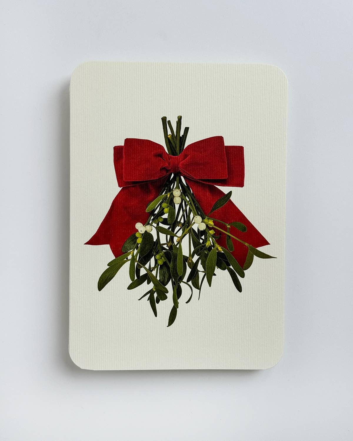 Archivist luxury card with mistletoe and red velvet bow on textured white paper