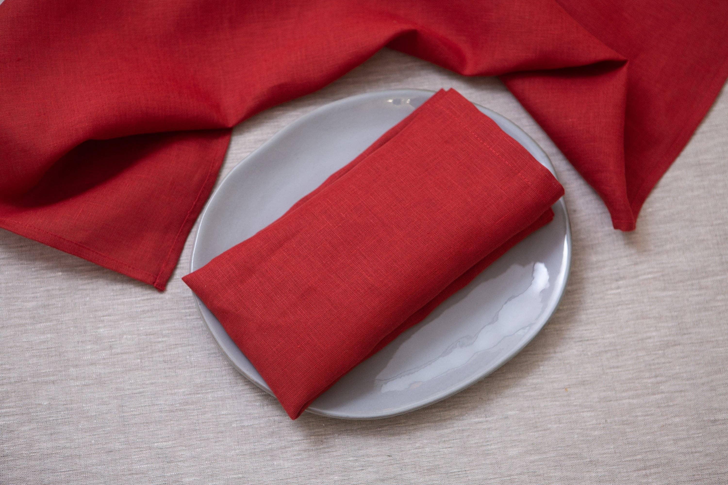 Red linen napkin by Solino Home on a grey plate, premium table setting.