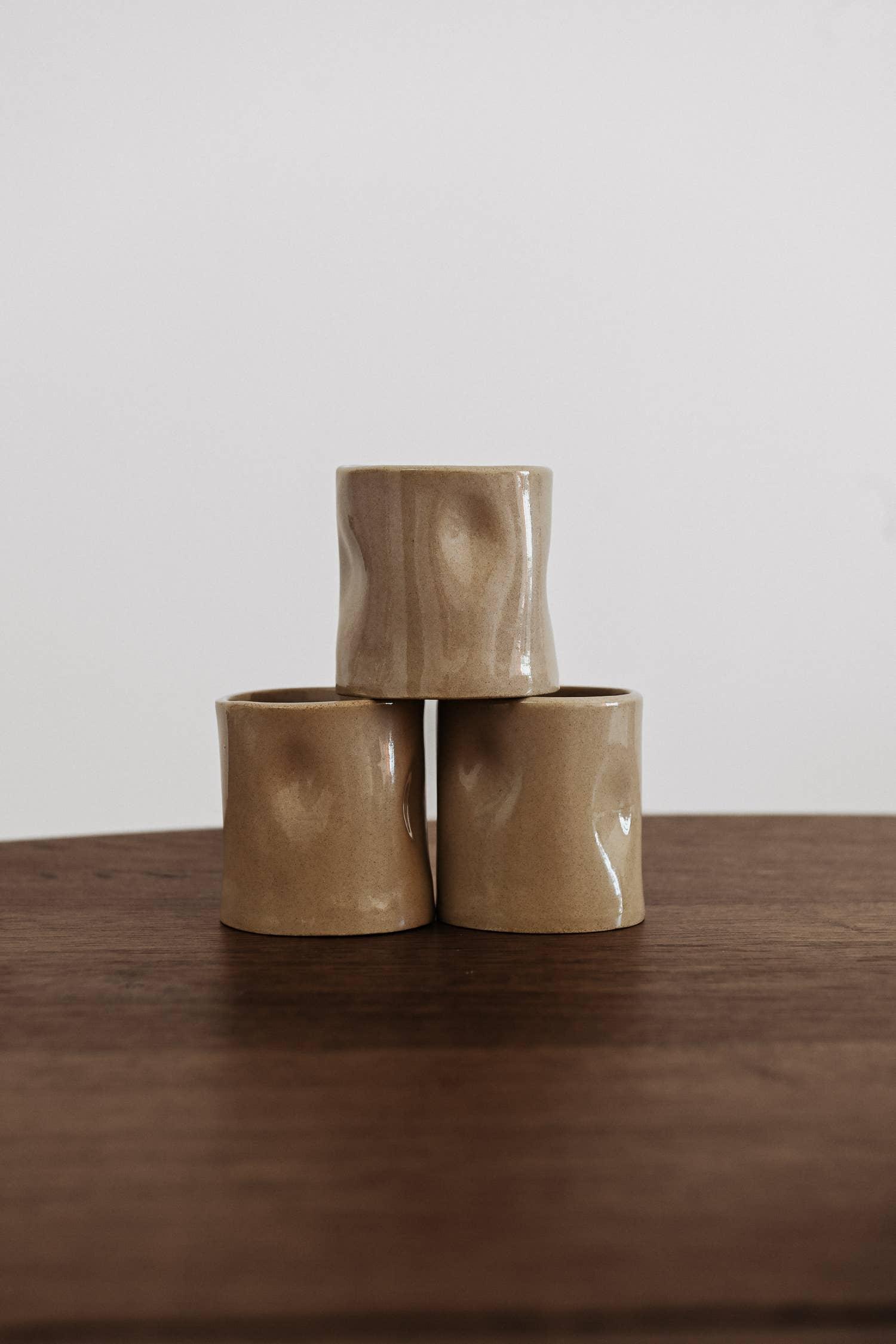 Maya Blu ceramics beige handcrafted stoneware cups stacked on a wooden table