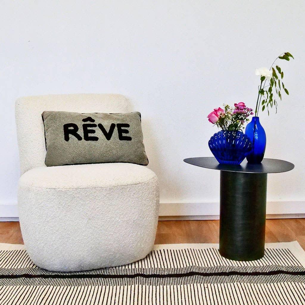 Rêve cream boucle accent chair with wool pillow, black metal side table, blue glass vases with flowers