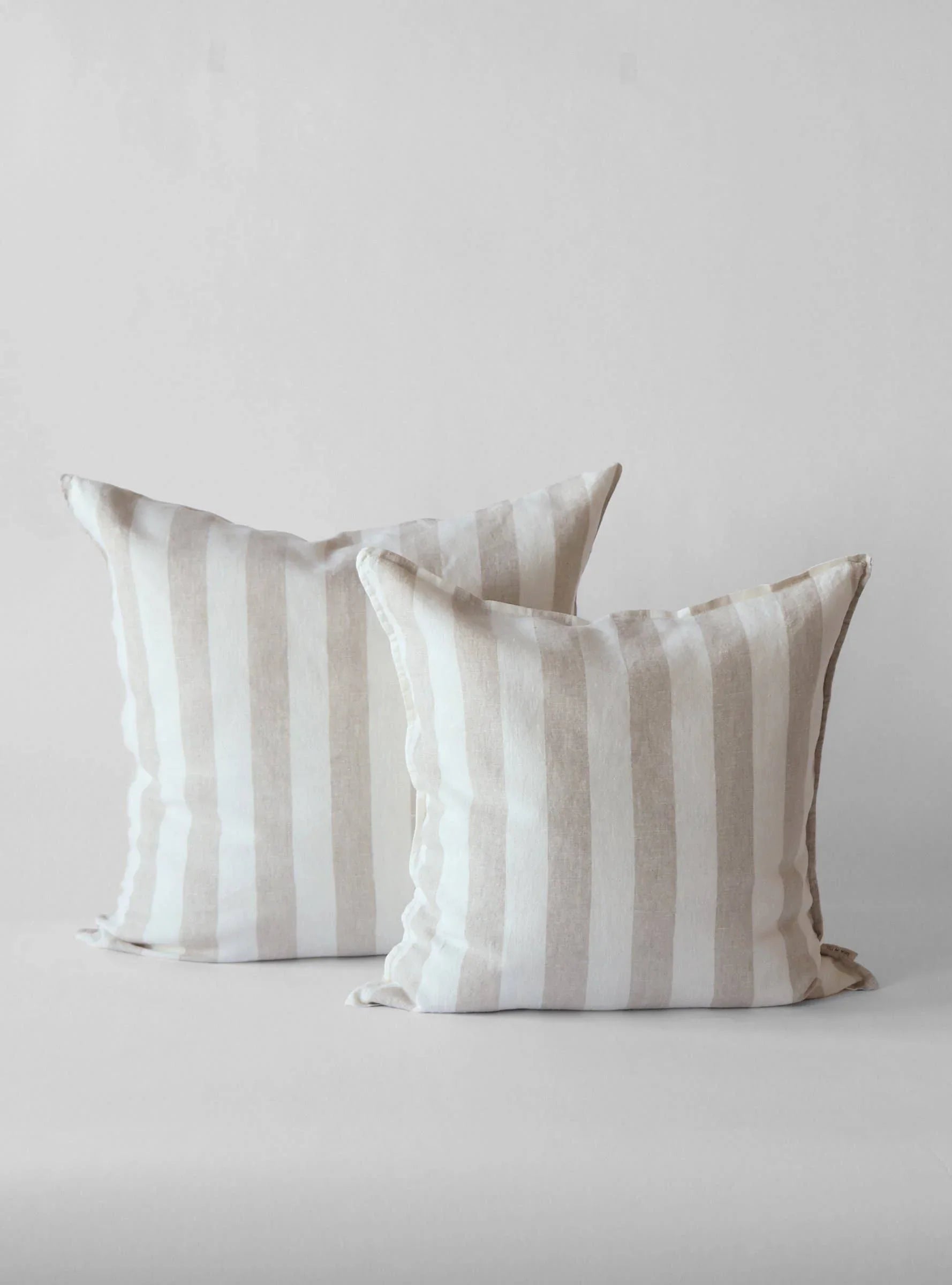 Two Studio McGee striped linen pillow covers in beige and white on a neutral background