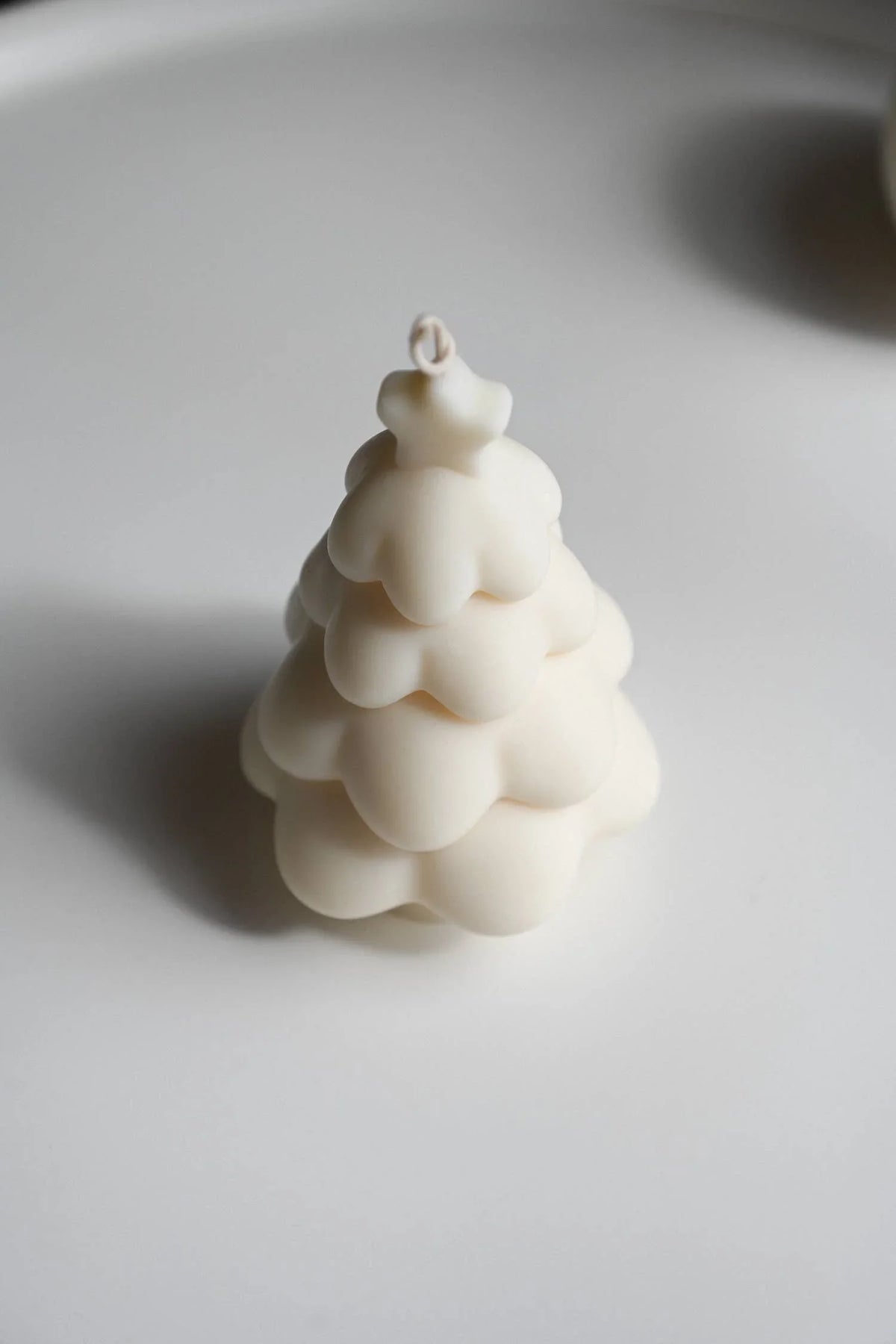 Lalume tree-shaped soy wax candle in matte white on a minimal background