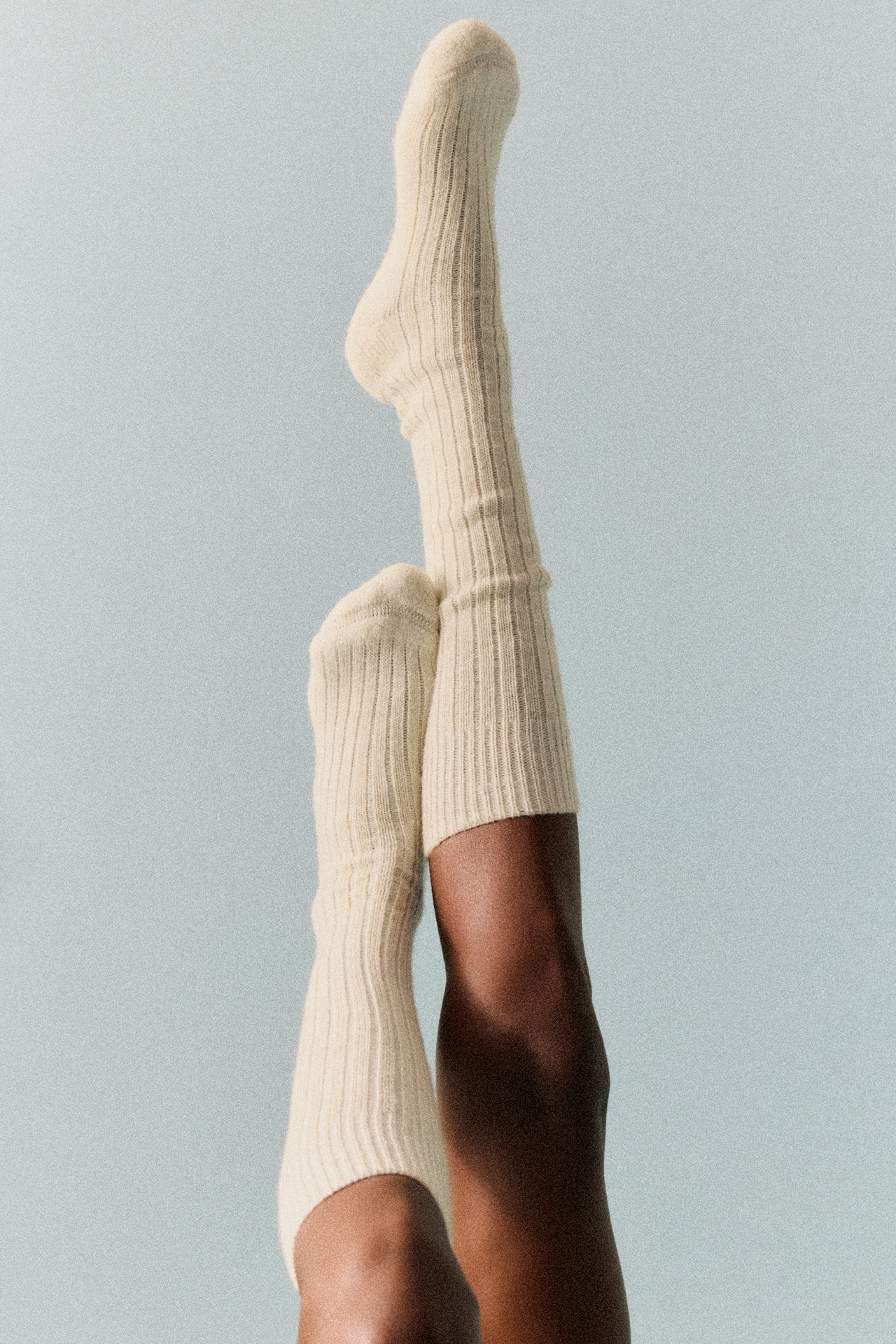 Le Bon Shoppe ribbed wool blend cream socks on model's legs, minimalist background