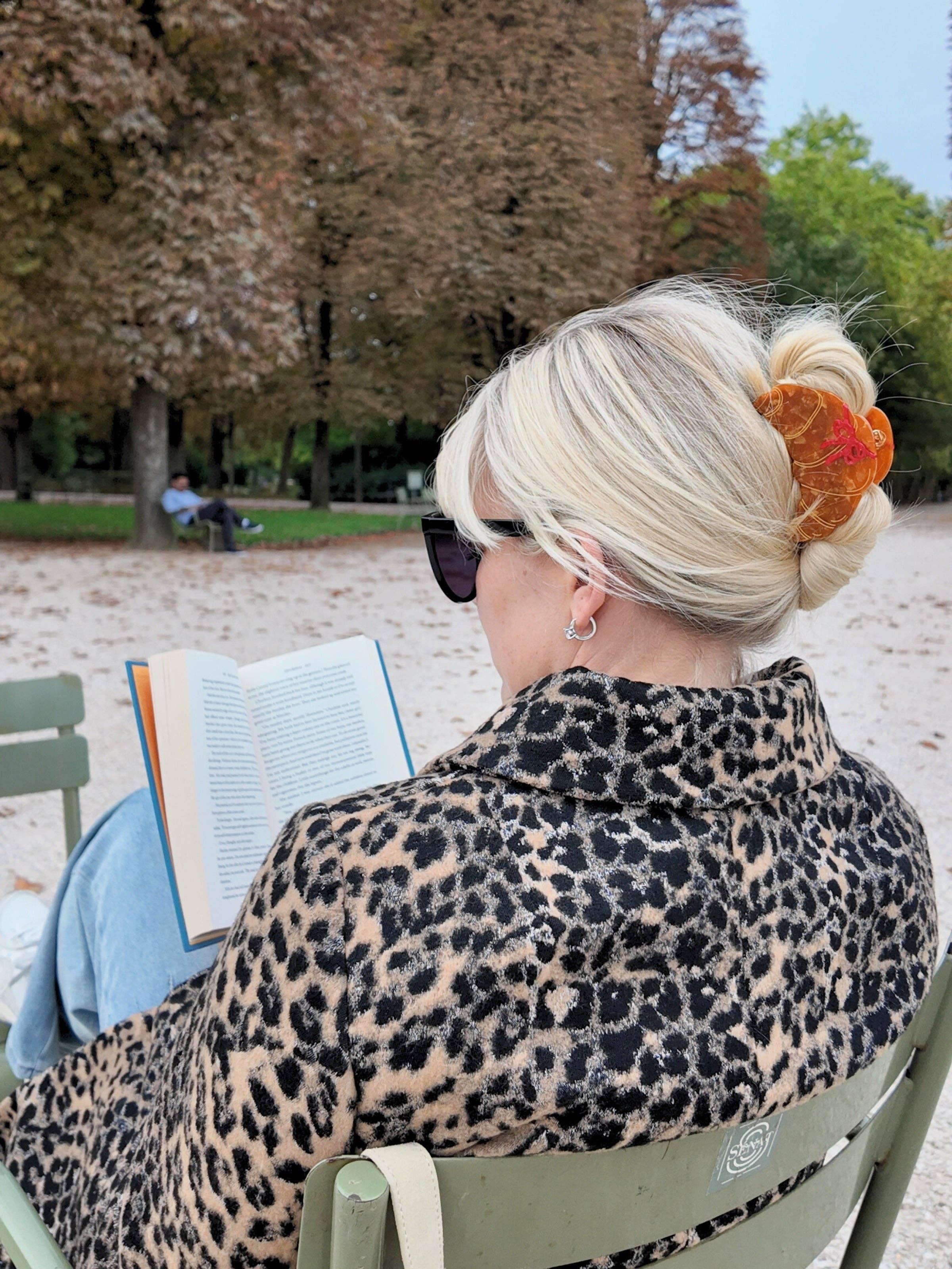 France Luxe tortoise shell hair claw on blonde woman, leopard coat, outdoor park setting