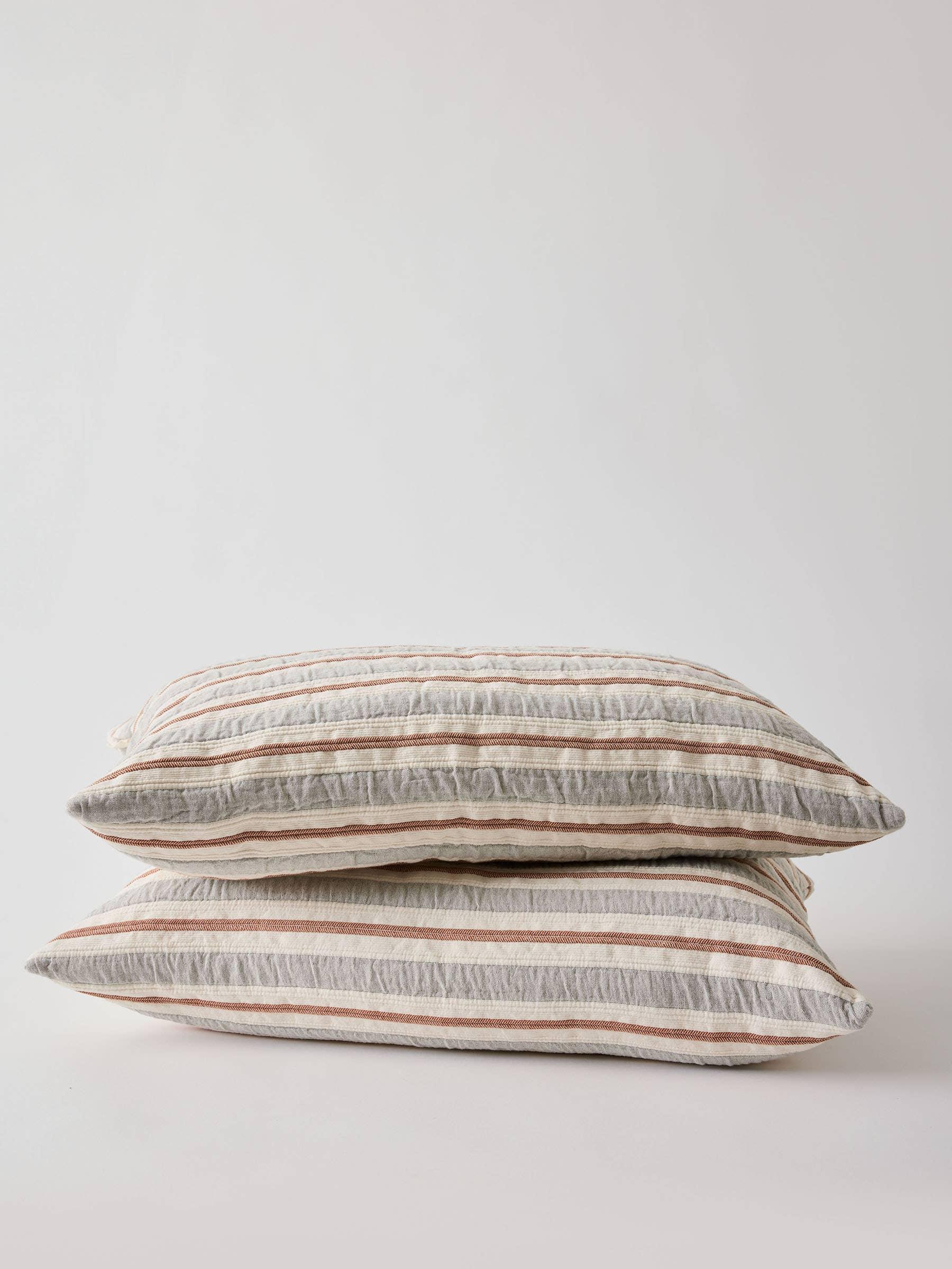Studio Kaiser Idell striped linen pillows in beige, grey, and rust on white background