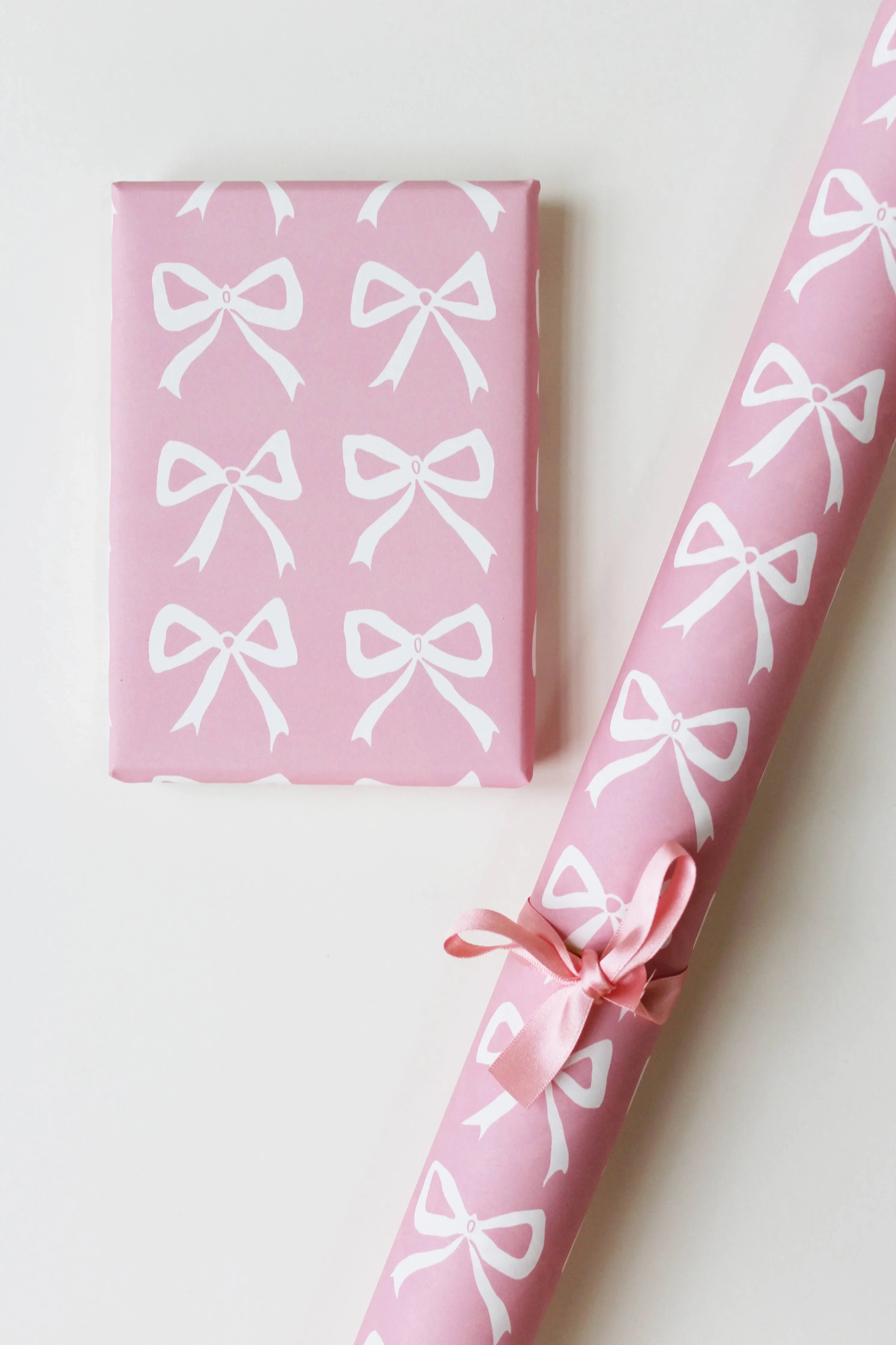 Crisp Packet Project pink gift wrap with white bow pattern, premium paper roll and box