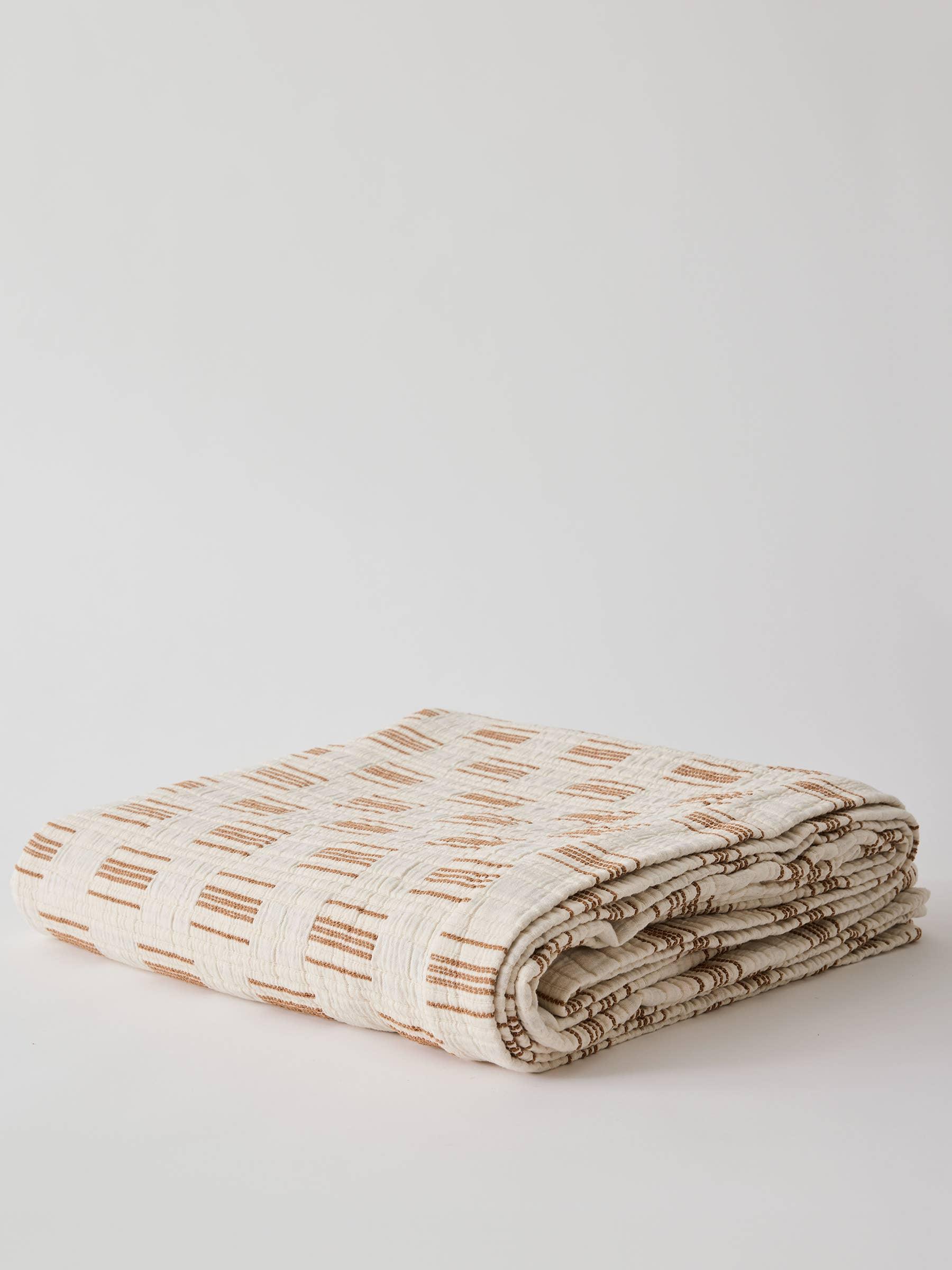 Letto Fold throw blanket, cotton, ivory and tan checkered pattern, folded on white background