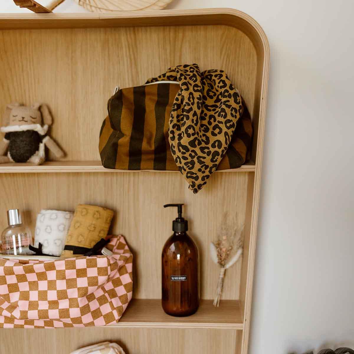 LIEWOOD toiletry bag in brown stripes and leopard print on wooden shelving unit