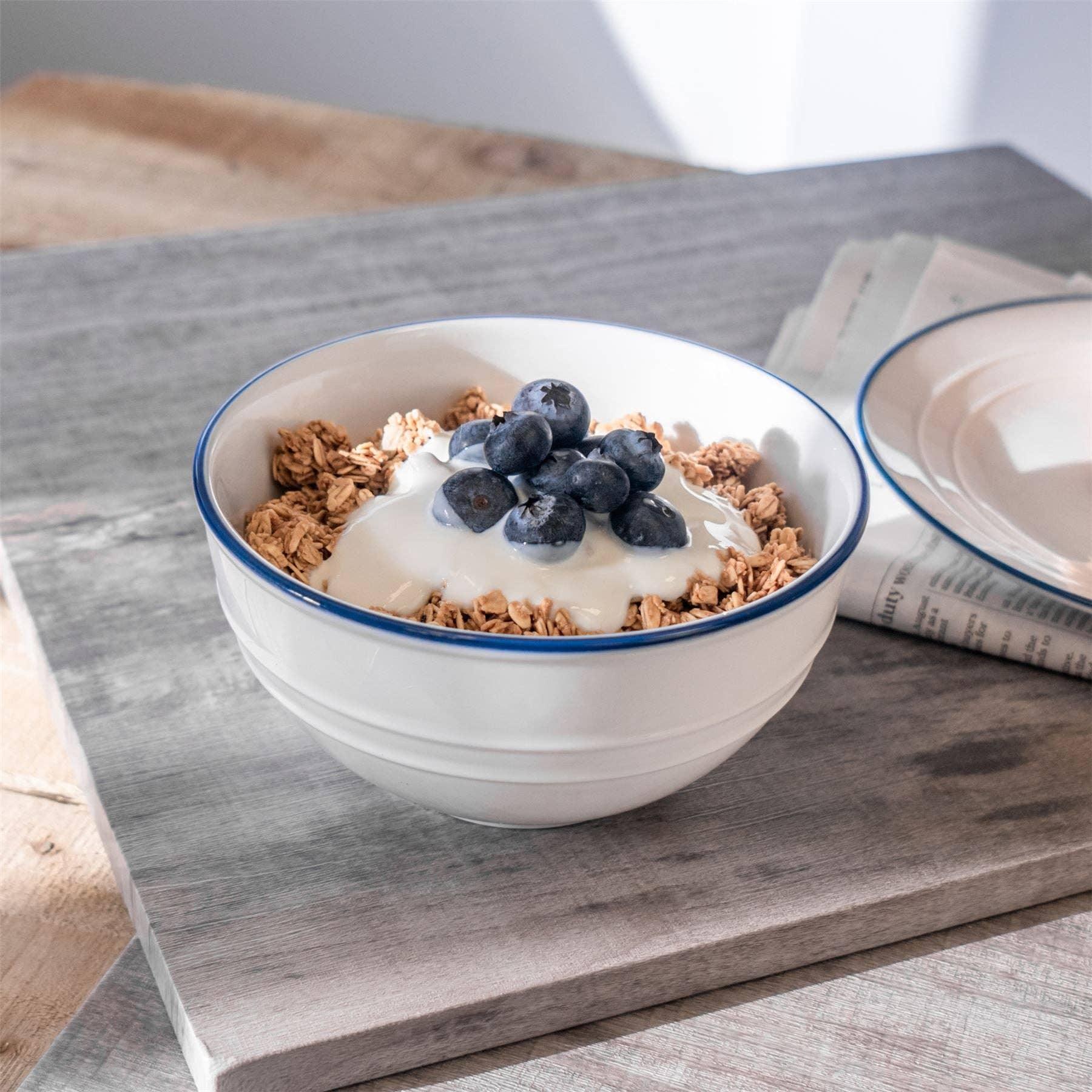 Cornishware ceramic cereal bowl white with blue rim, filled with granola, yogurt, blueberries