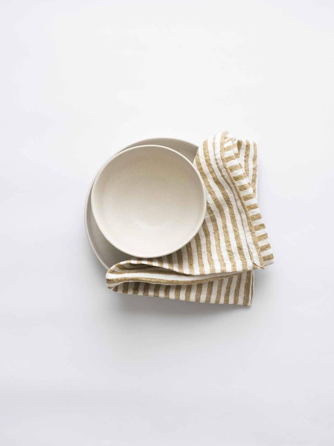 Hasami porcelain bowl and plate with beige striped linen napkin on white background