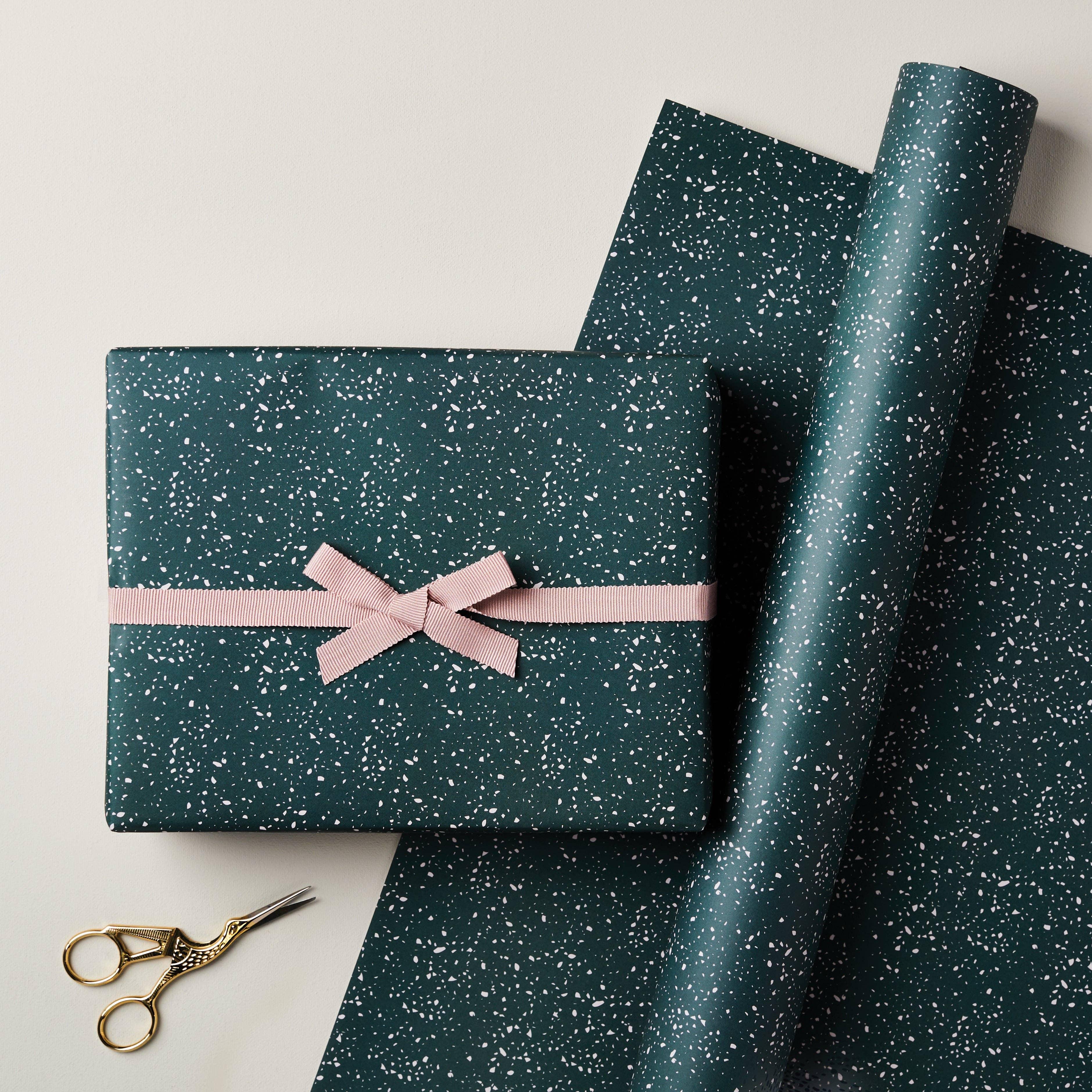 Dear Maison dark green speckled wrapping paper with pink ribbon and gold scissors