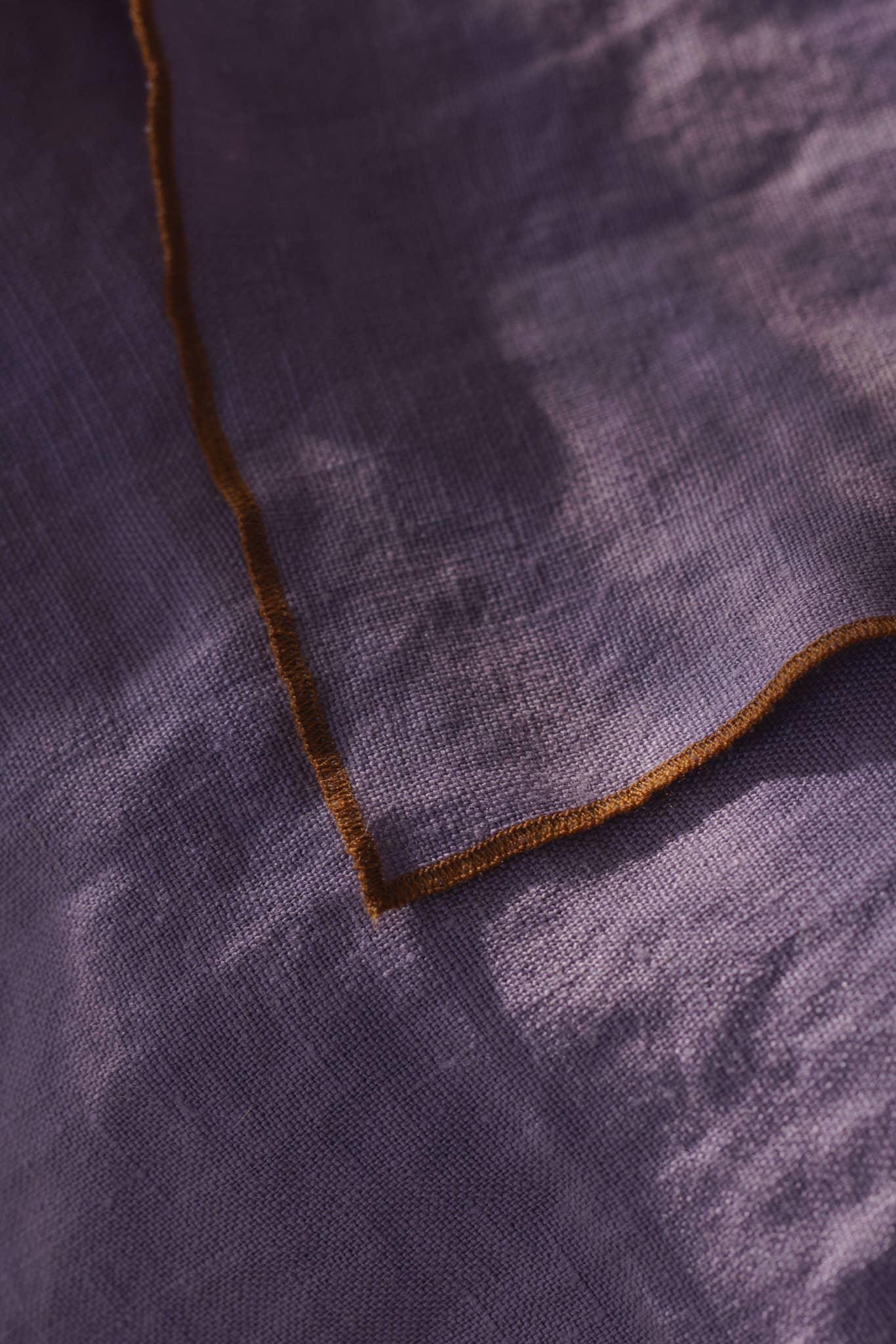 Hexa linen napkin in purple with brown trim, premium textured fabric detail