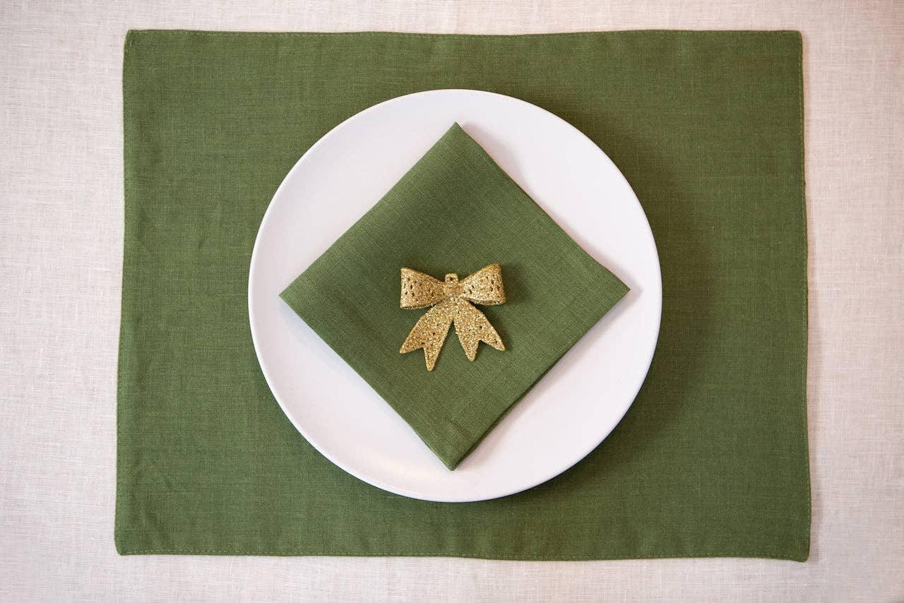 Maison Margot green linen placemat and napkin set with gold bow accent on white plate
