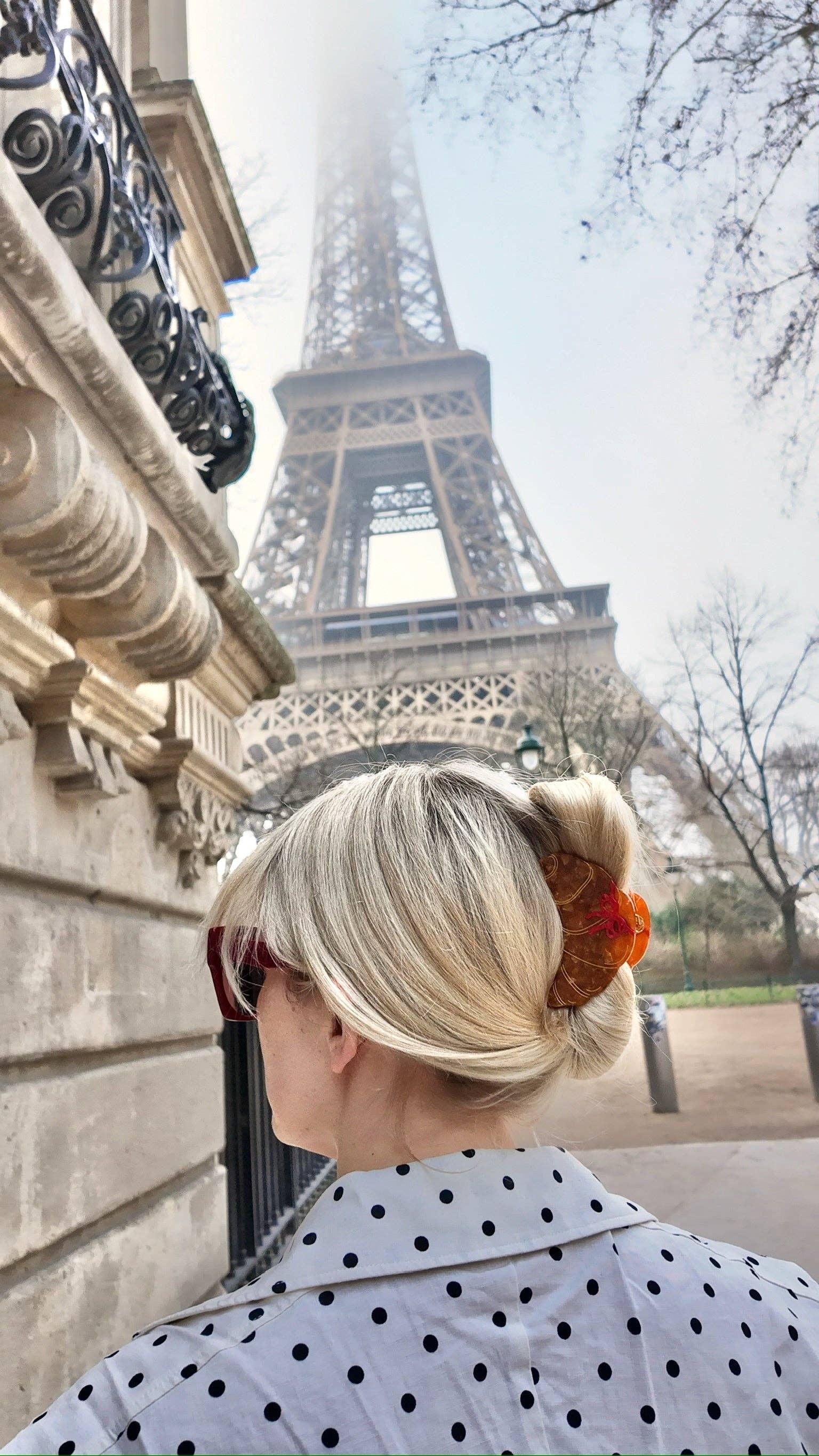France Luxe tortoise shell hair clip in blonde hair, polka dot shirt, Paris Eiffel Tower background