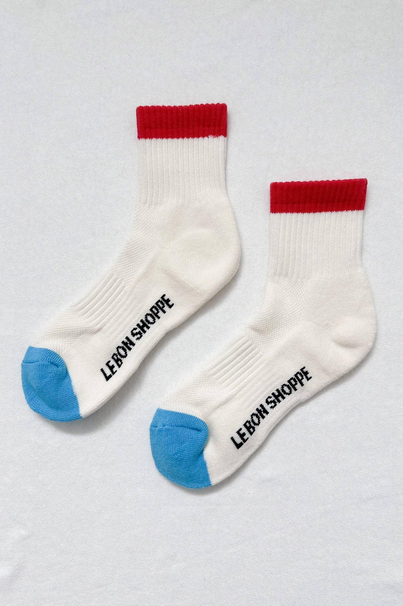 Le Bon Shoppe white cotton crew socks with red cuffs and blue toes, black logo text