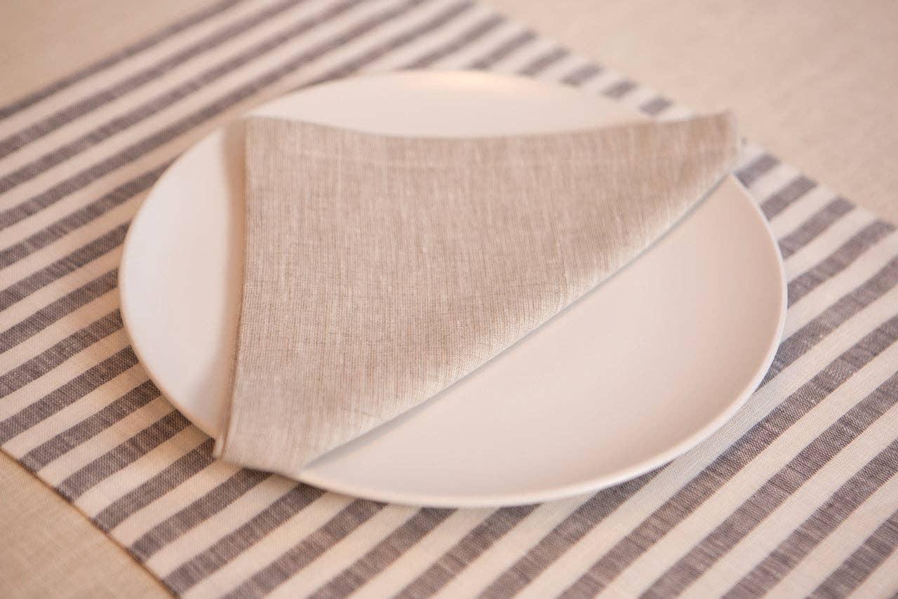MagicLinen beige linen napkin on white plate, grey striped linen placemat