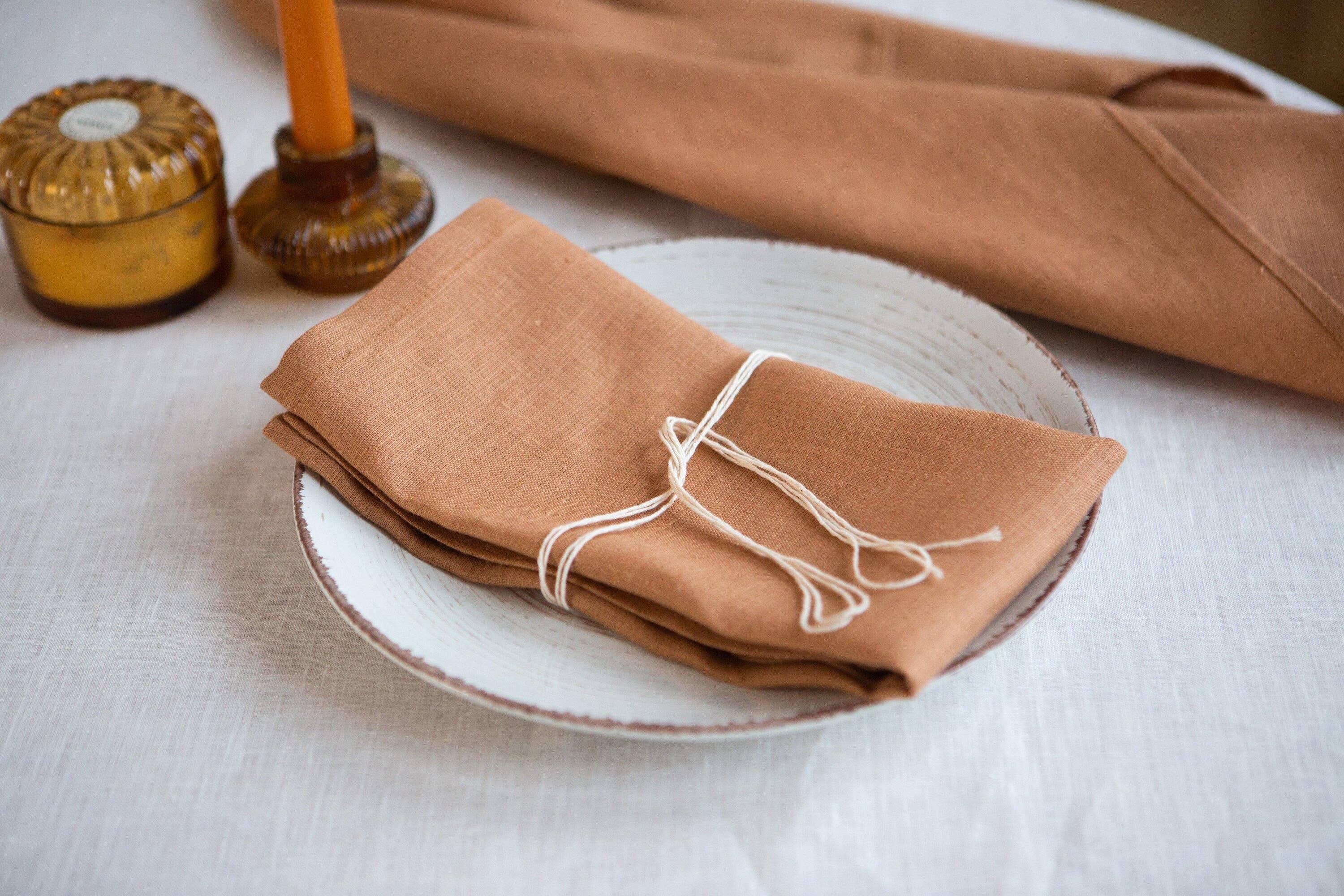Studio Herron linen napkin in terracotta color on ceramic plate, premium table setting