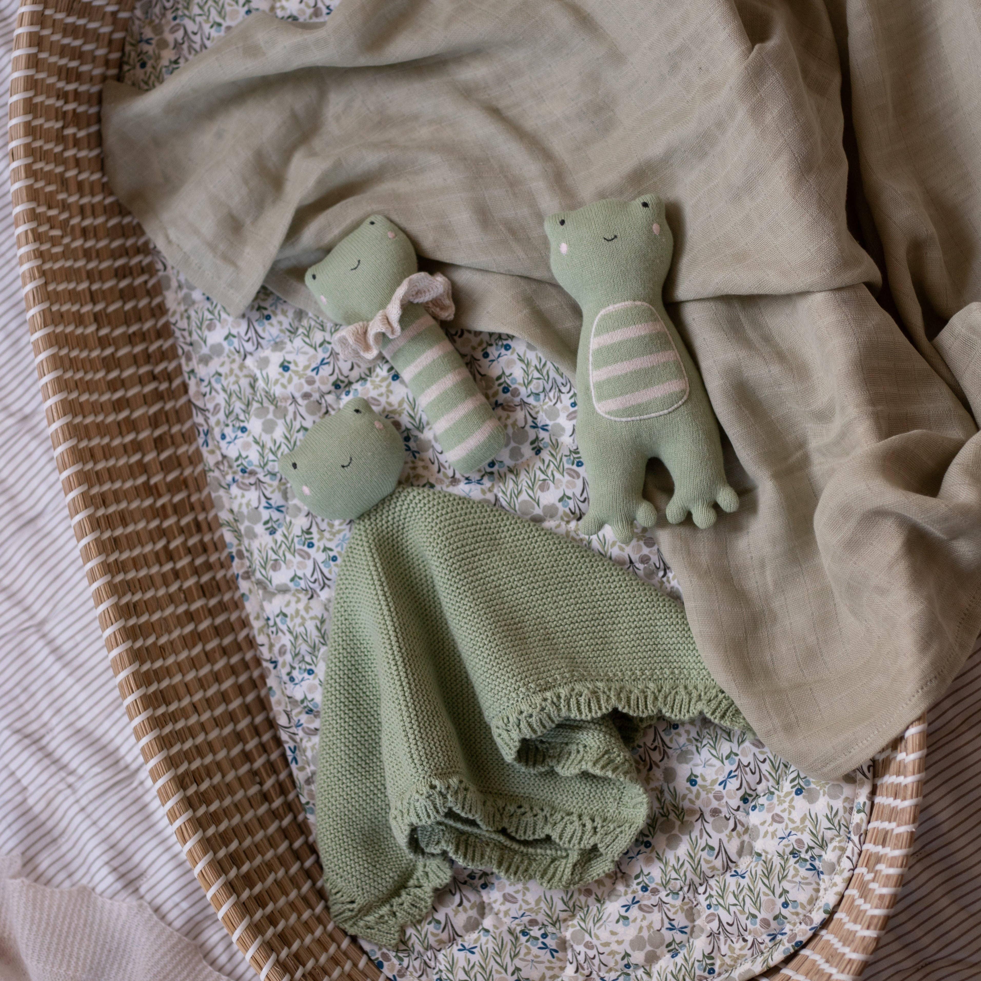 Konges Sløjd soft green knit frog plush toys and comforter in woven Moses basket