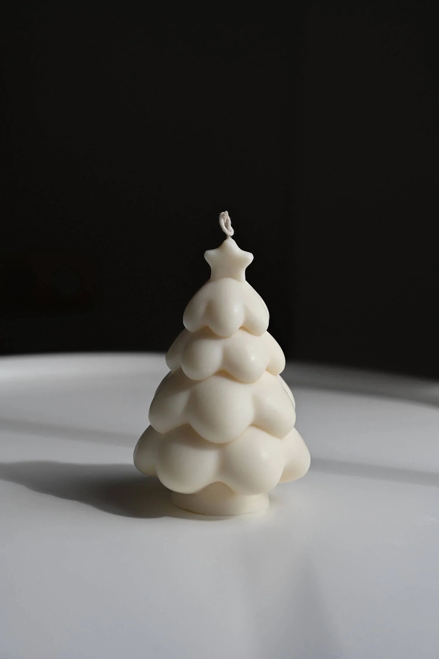 Sicily Hill white soy wax Christmas tree candle with star top on white surface