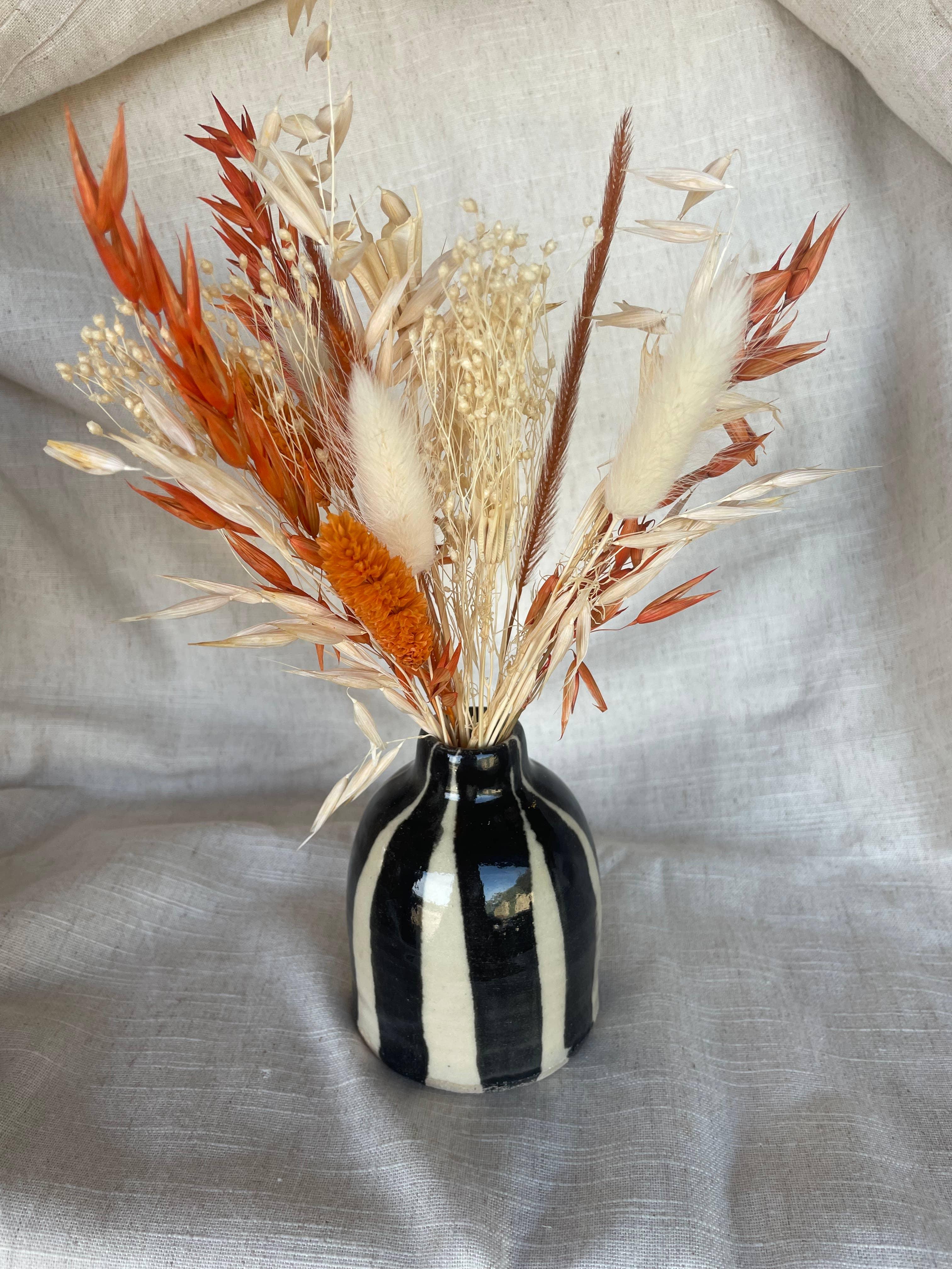 Handmade striped ceramic vase by Earth and Elements with dried flower arrangement in neutral tones