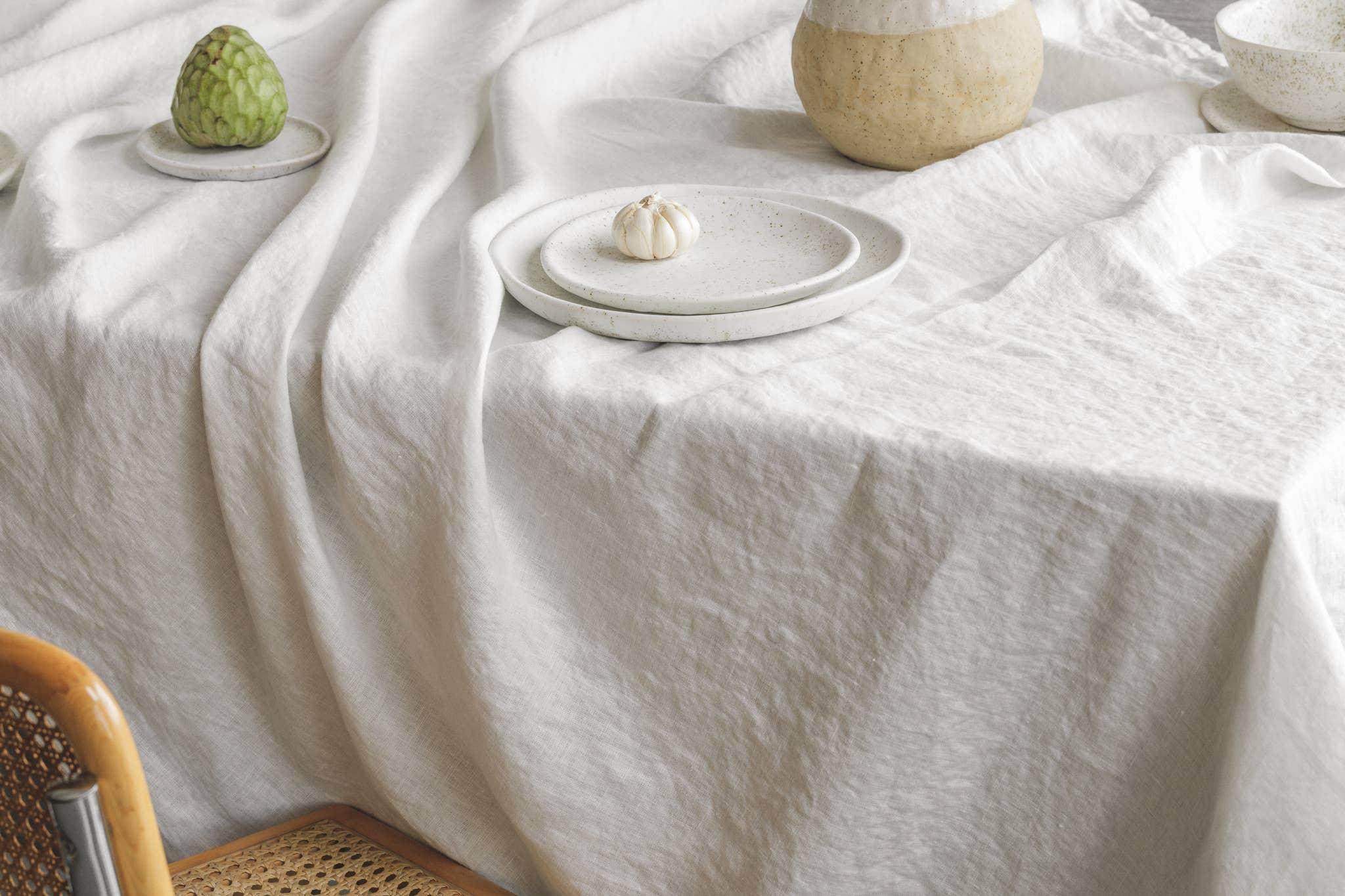 Maison De Vacances white linen tablecloth with ceramic plates and natural decor