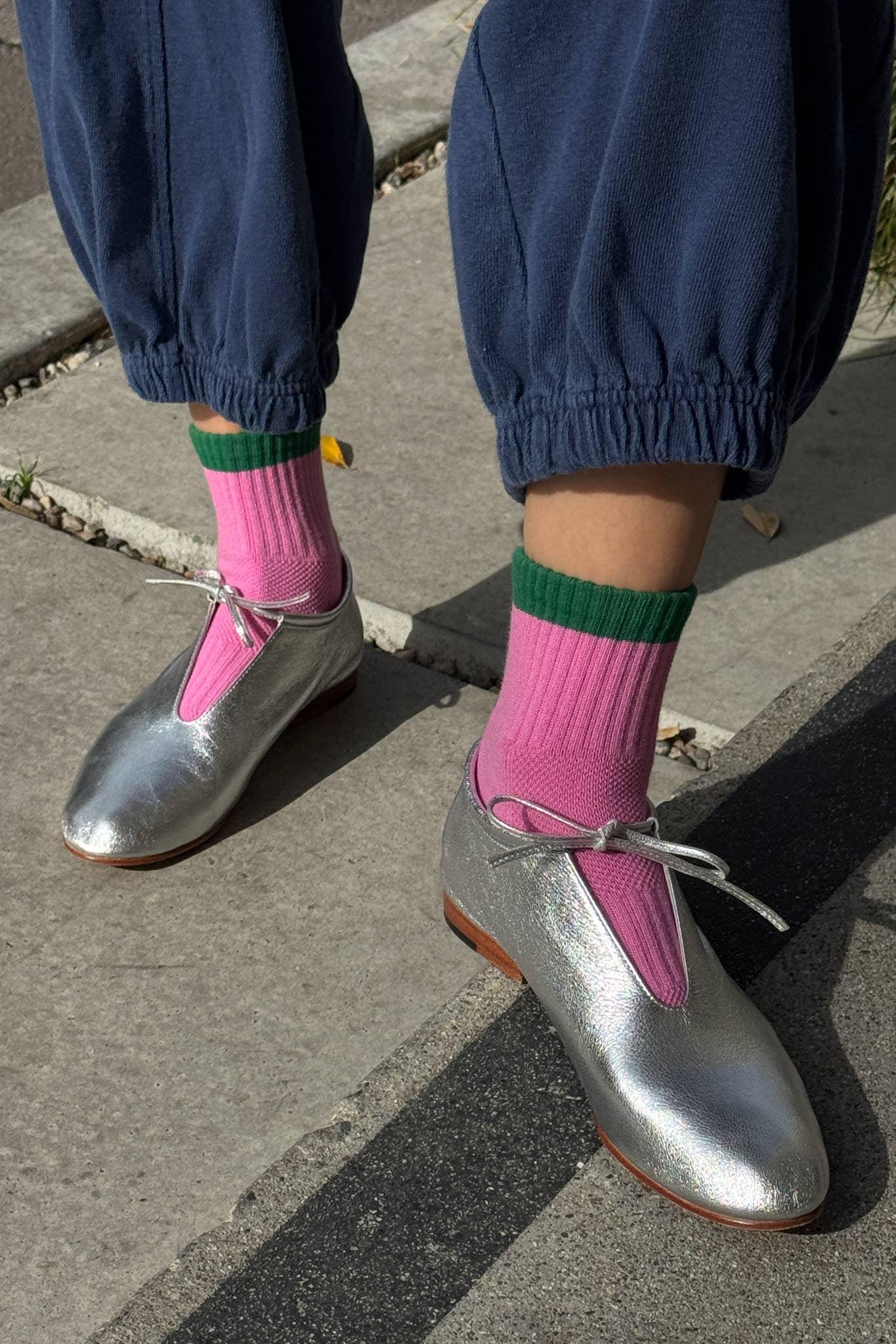 LOQ silver leather ballet flats with bow, worn with pink socks and blue pants outdoors