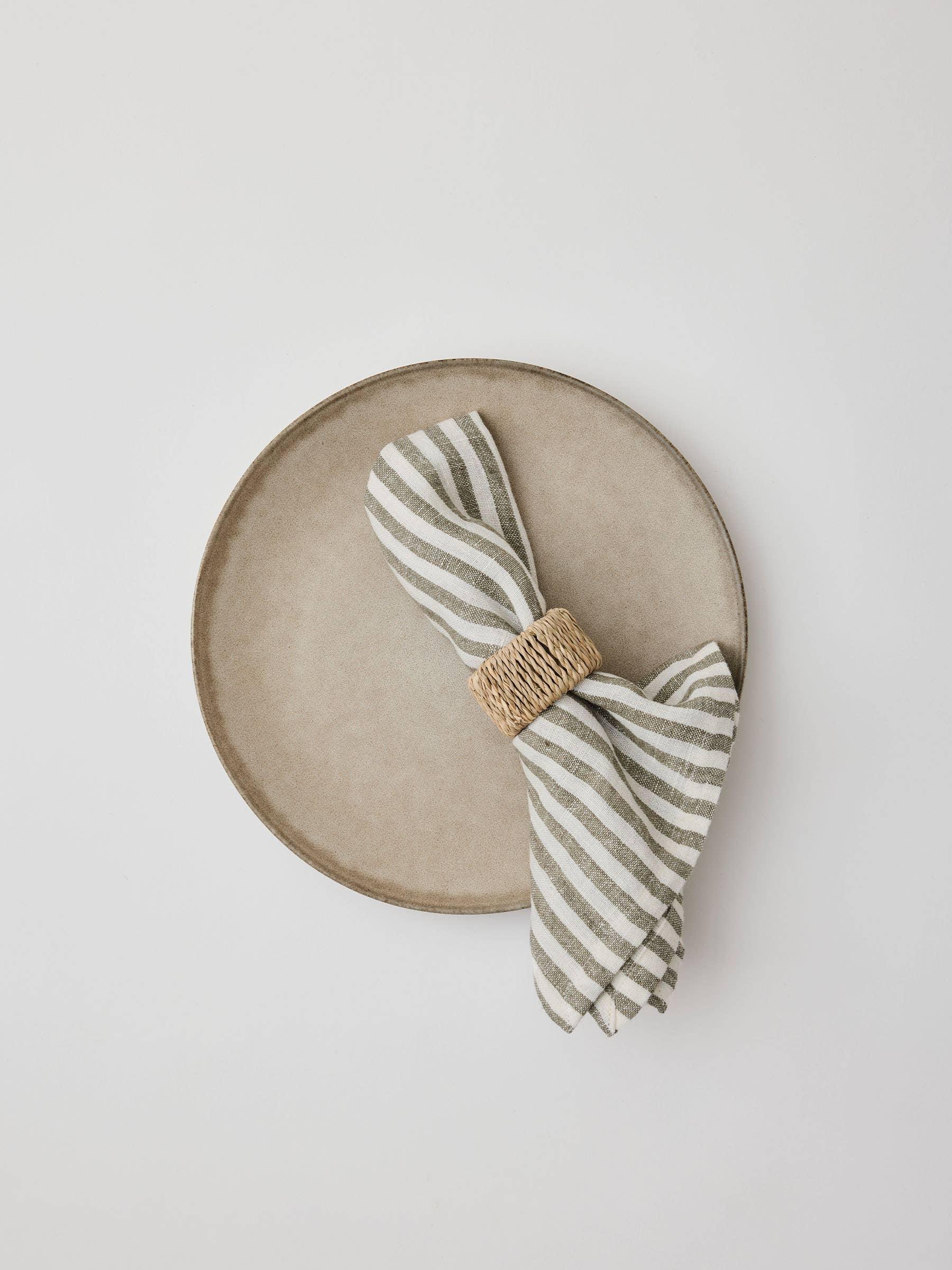 Fable stoneware plate with striped linen napkin and woven rattan napkin ring, beige and ivory