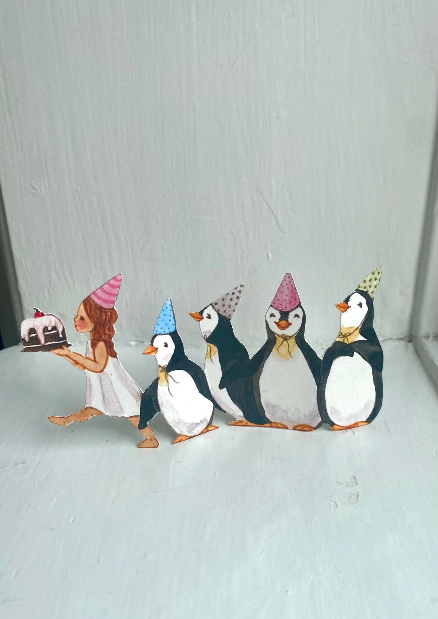 Anna Bruder hand-painted paper party scene with girl and penguins in pastel hats