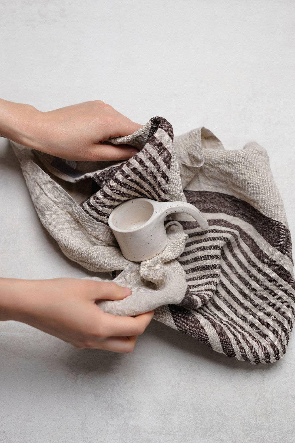 Fog Linen striped linen tea towel in beige and brown, with white ceramic cup