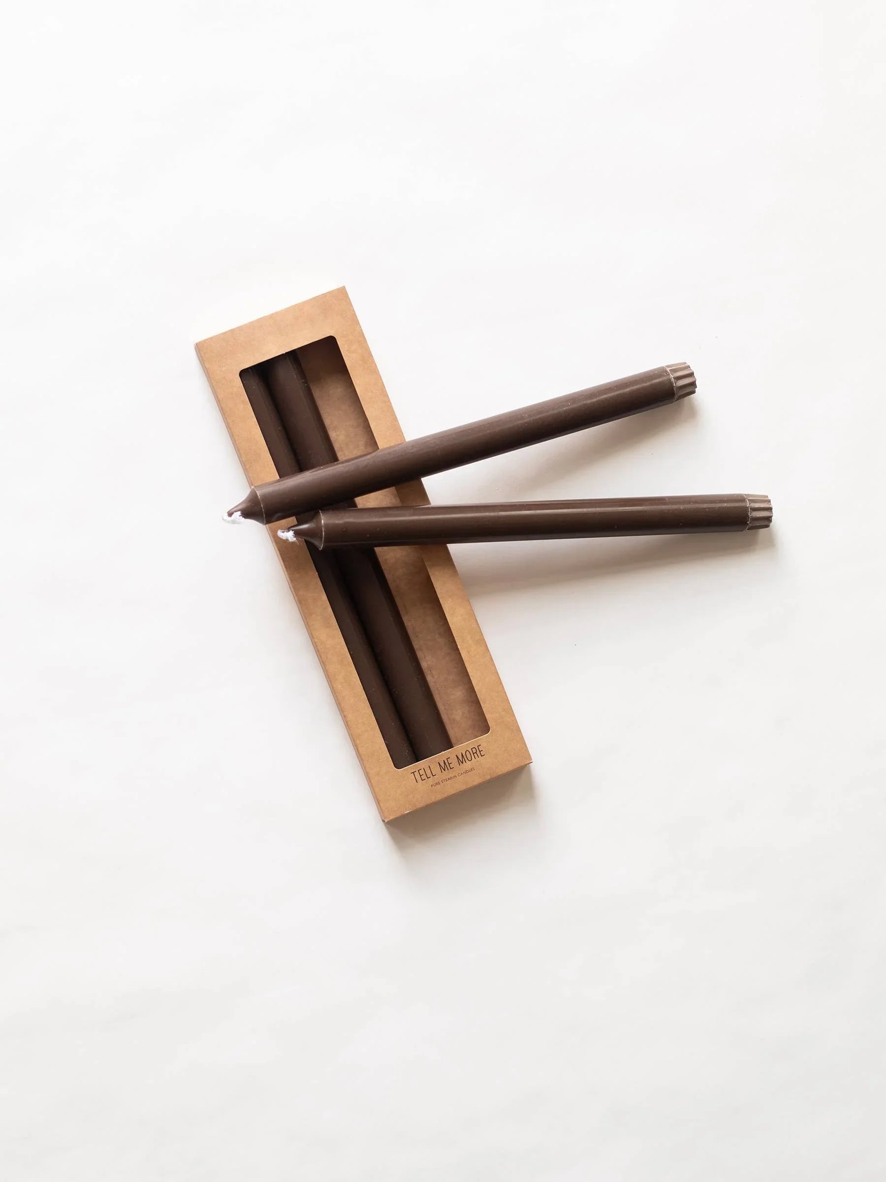 Tell Me More brown taper candles, wax, premium kraft box packaging on white surface