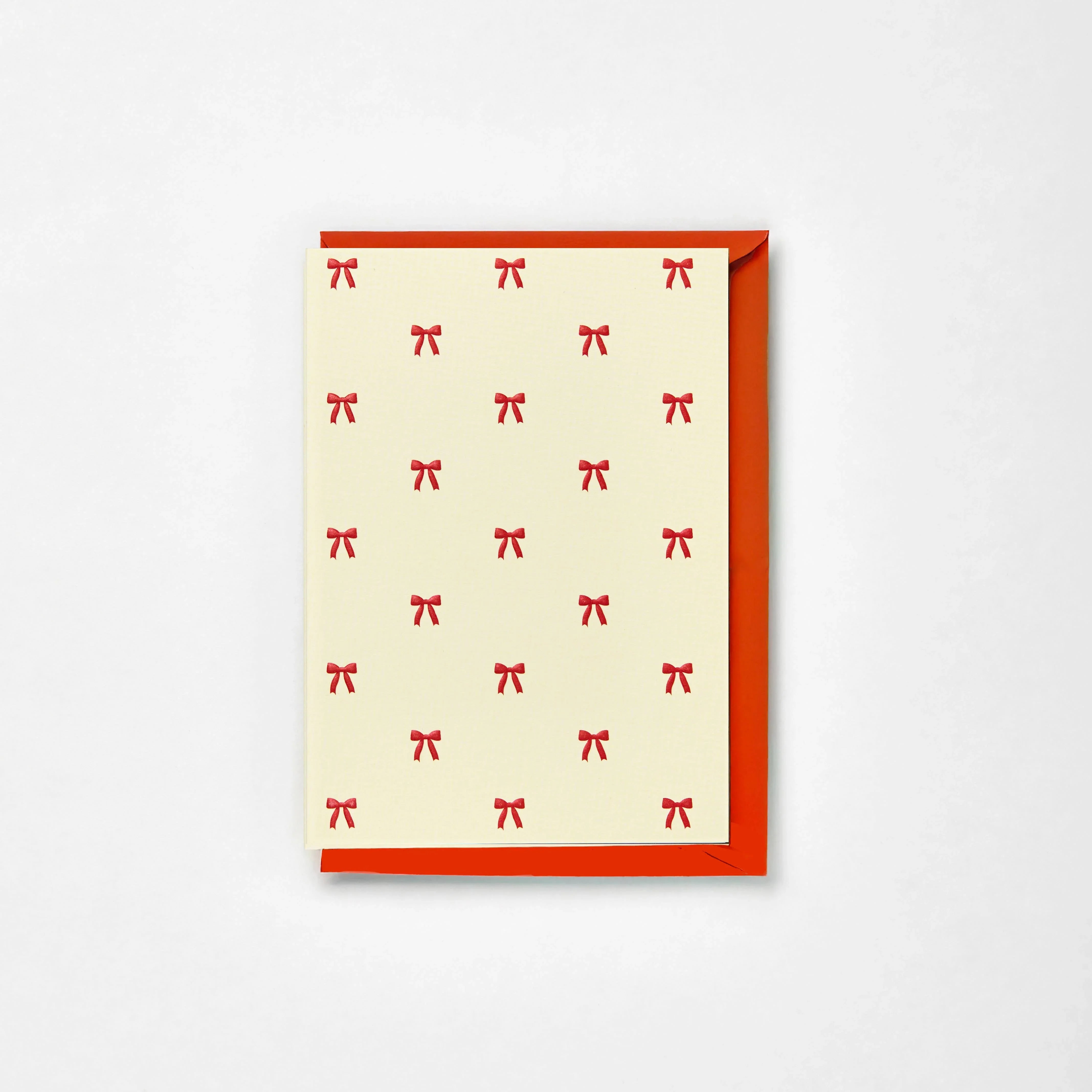 Rifle Paper Co. cream greeting card with red bow pattern and matching red envelope