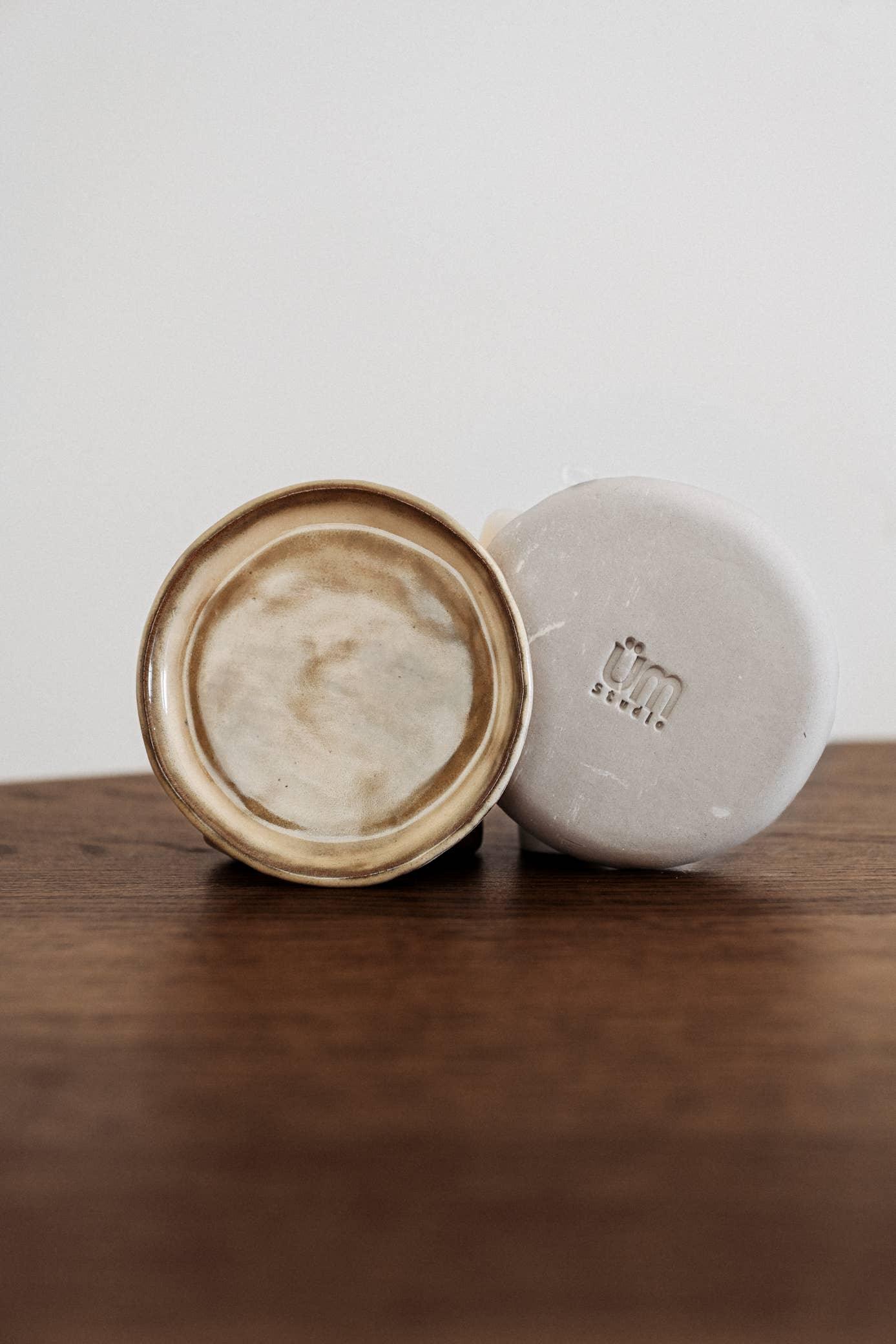 üm studio ceramic soap dish and beige soap bar on wood table