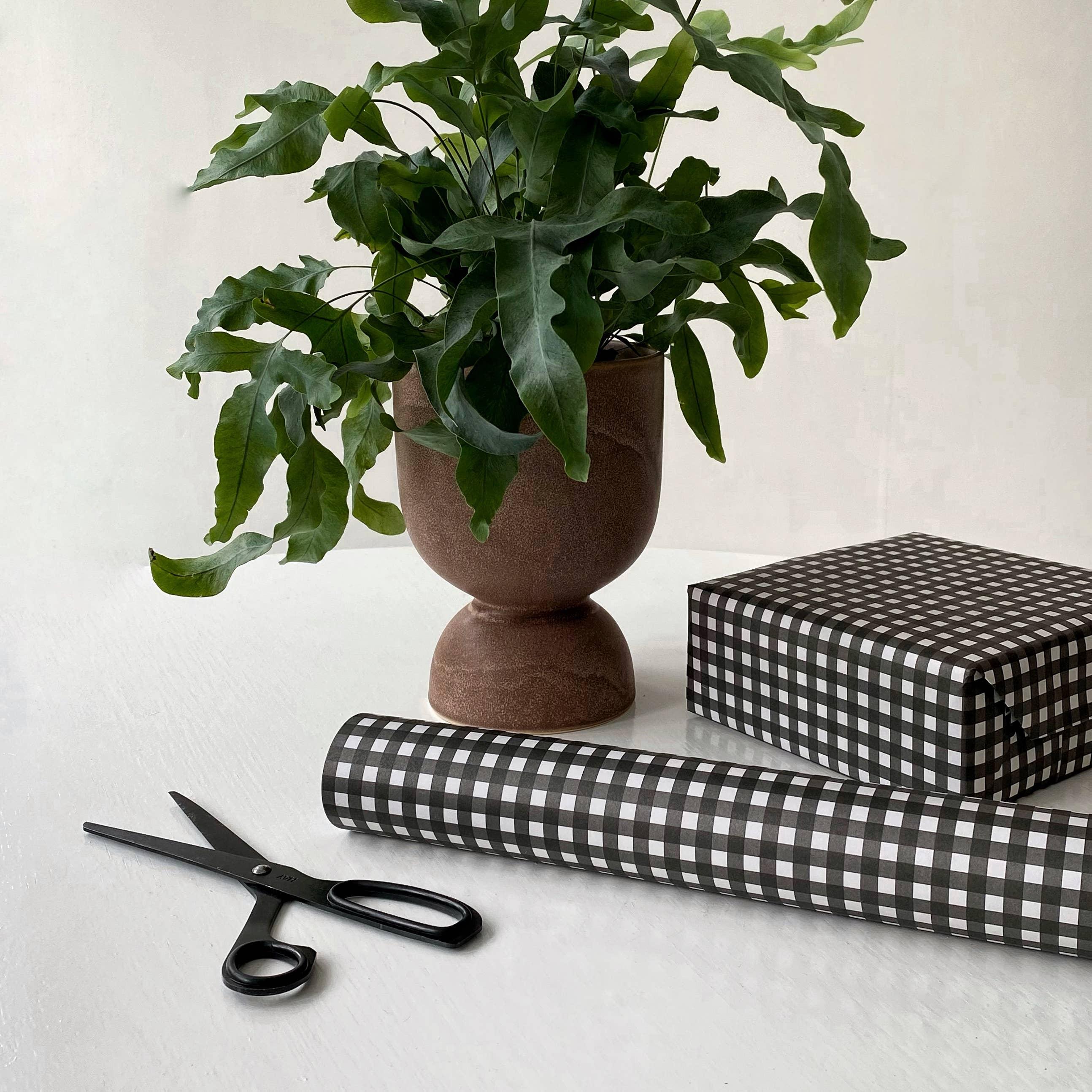 SUKIE black and white checkered gift wrap with scissors and potted plant on white table