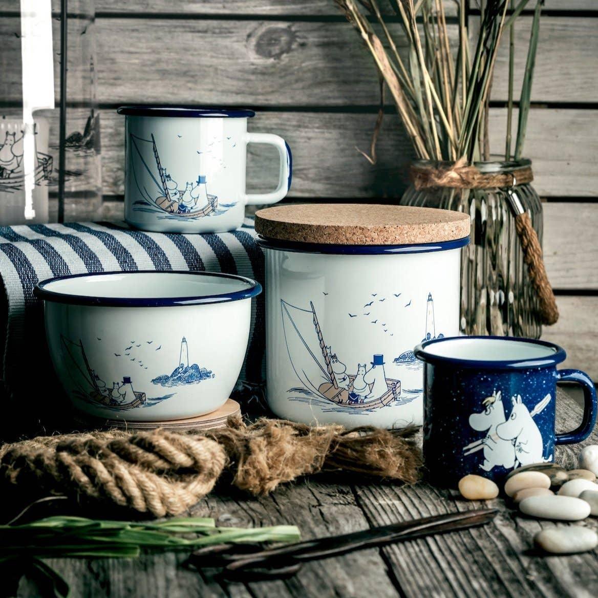Moomin enamel mugs and container set, white and blue, with nautical design on rustic wood