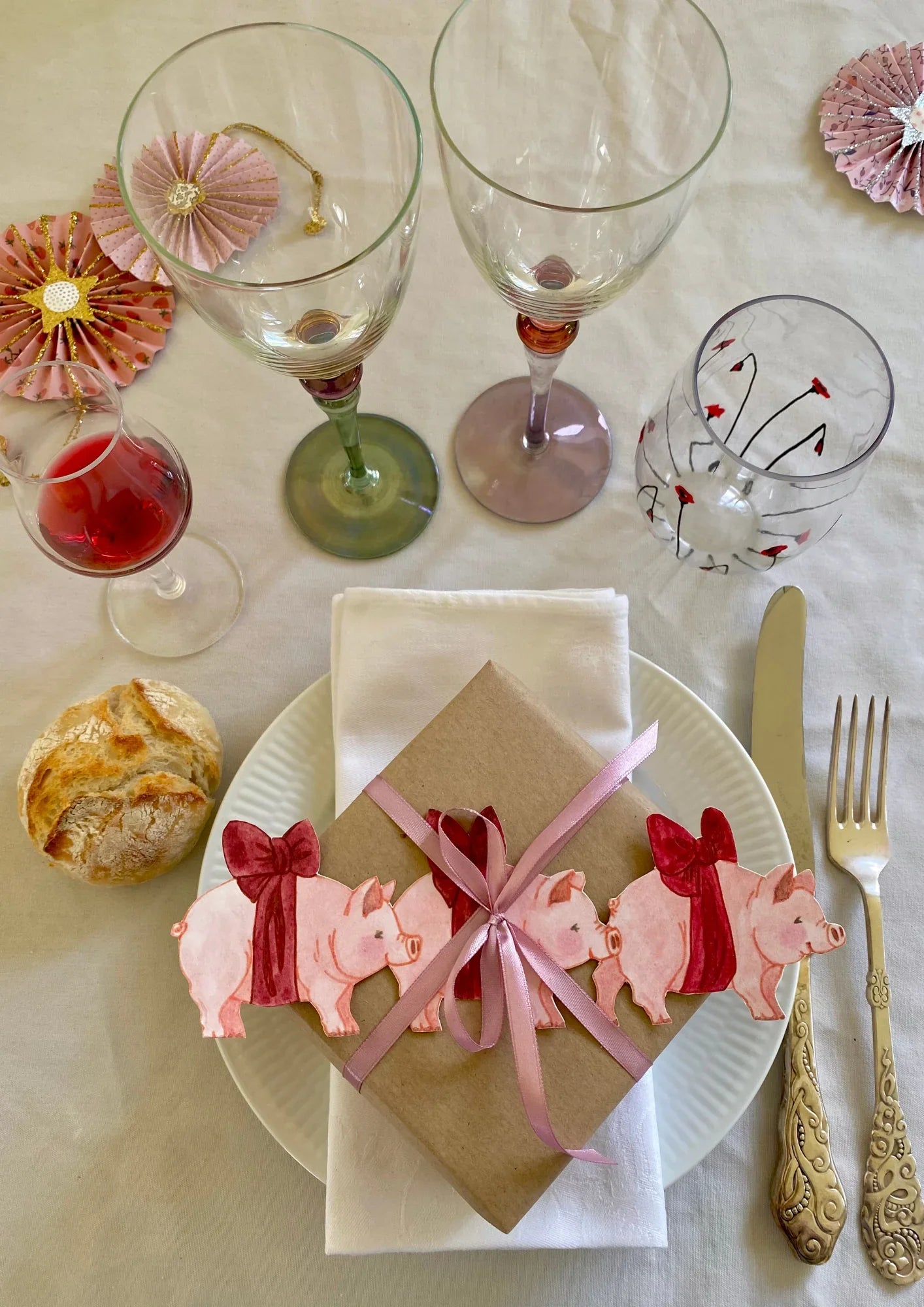 Studio Sarah Lou pig garland, kraft paper gift, pink ribbon, elegant table setting