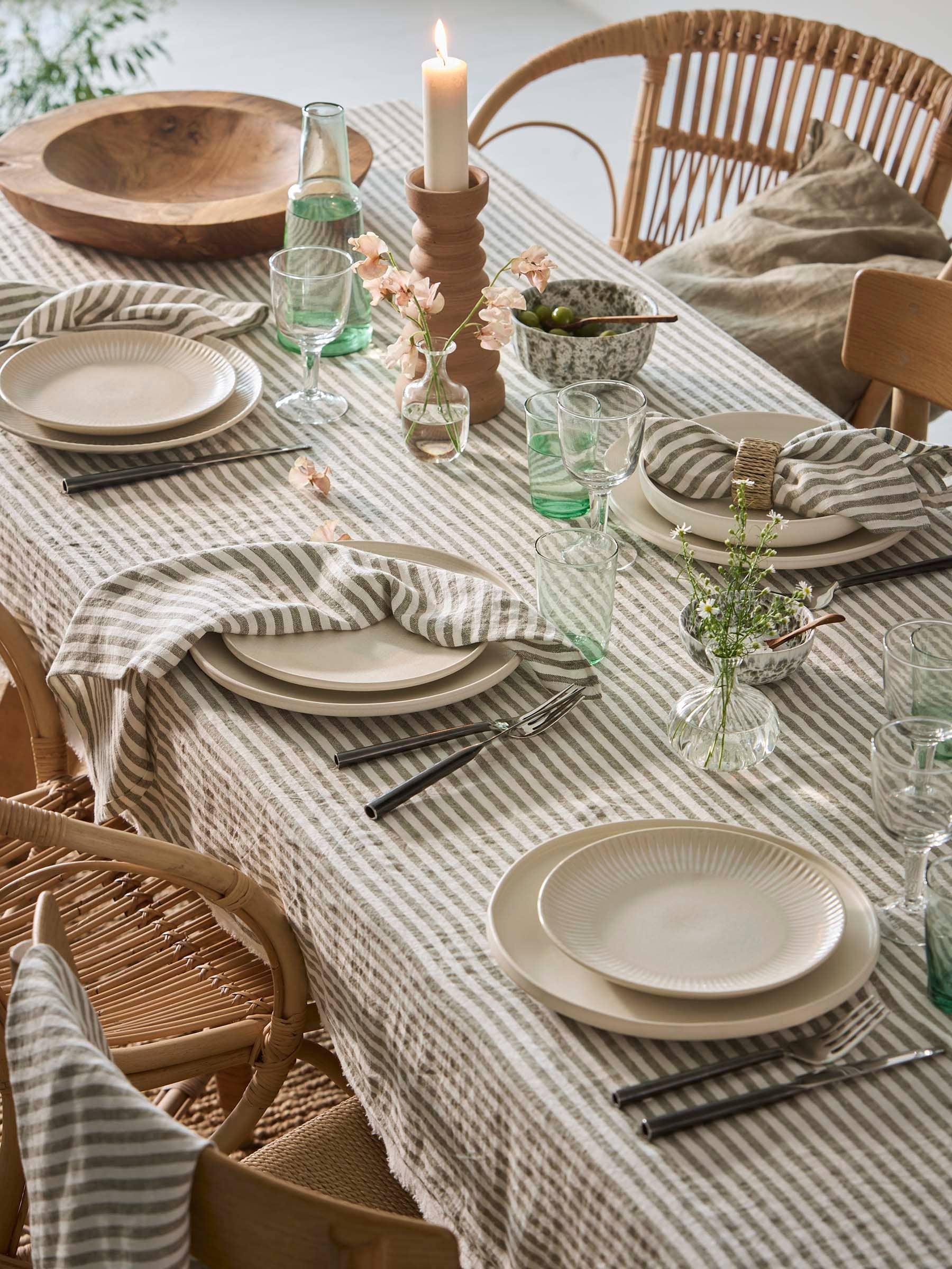 Broste Copenhagen striped linen tablecloth, stoneware plates, glassware, neutral decor