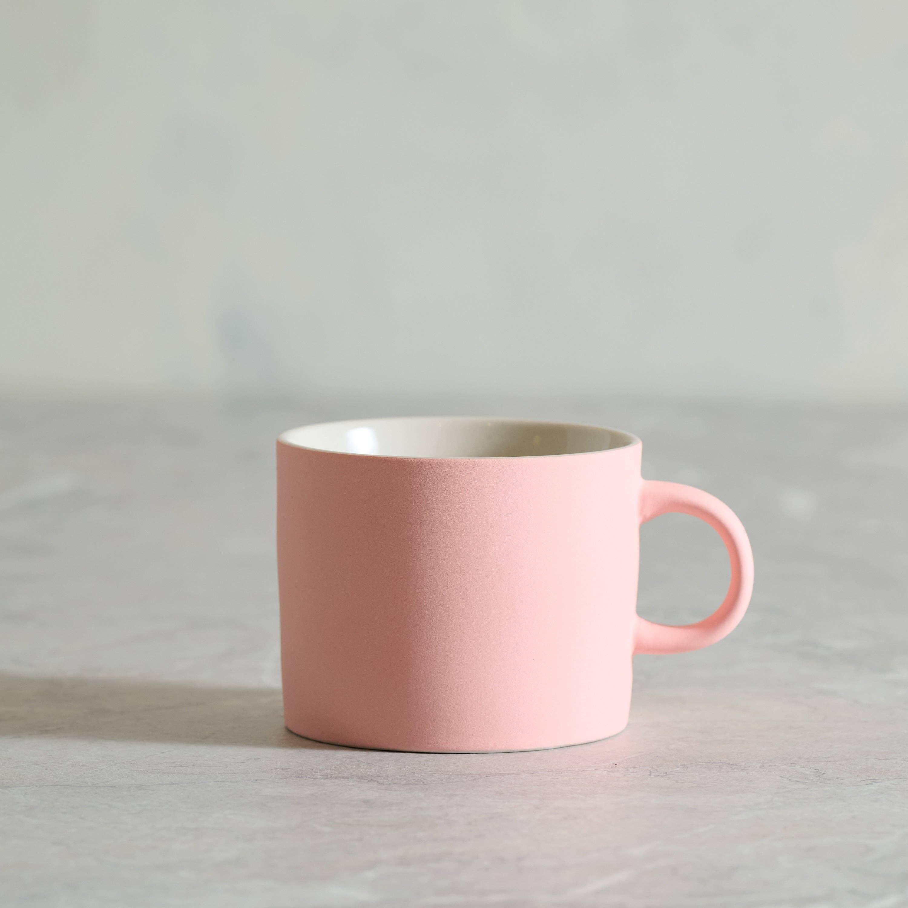 Kinto ceramic mug in matte pink, premium stoneware coffee cup on grey background
