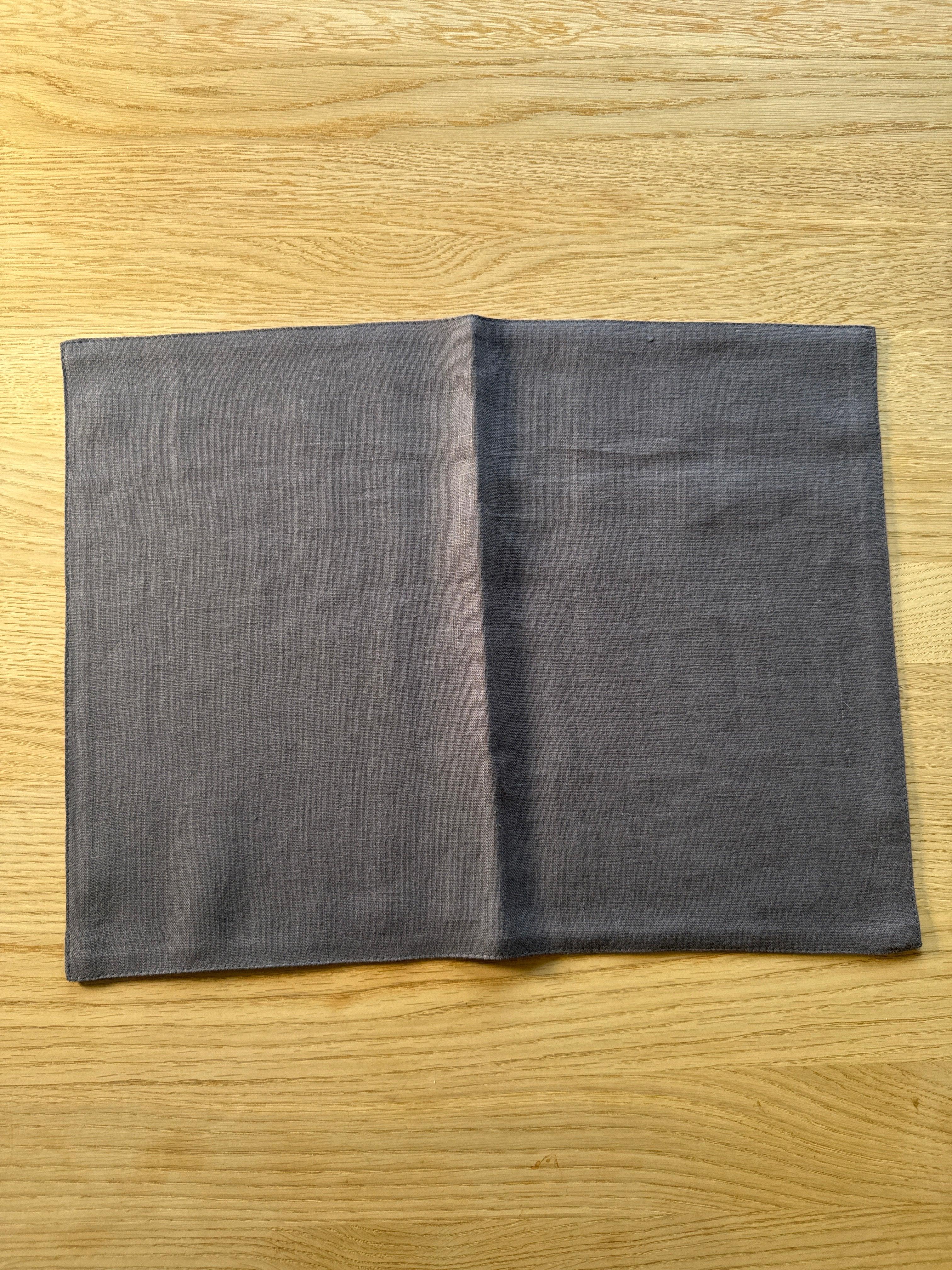 Studio Mykos grey linen placemat on light wood table