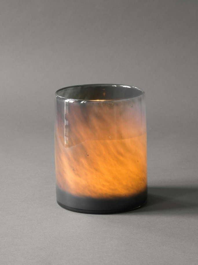Audo smoked glass candle holder with amber and black gradient on grey background