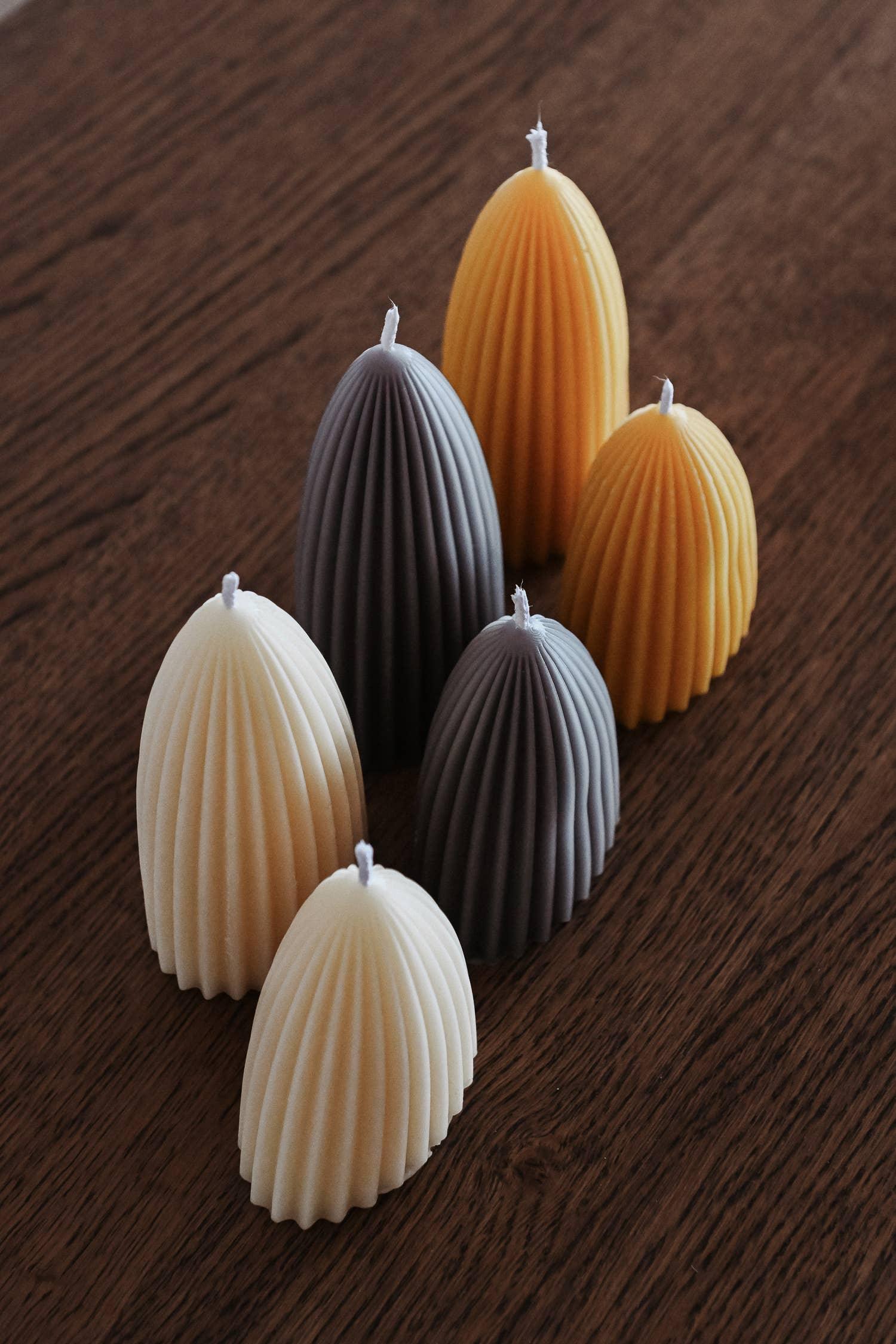 Pleple pleated soy wax candles in cream, grey, and yellow on wooden table