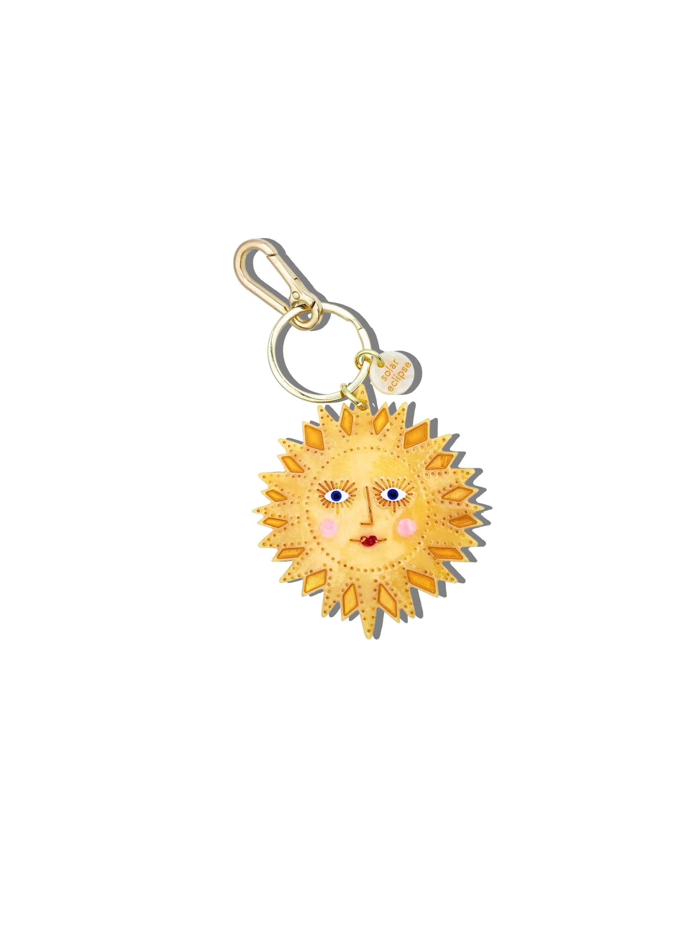 Solar Eclipse gold-tone sun face keychain with enamel detail and branded tag