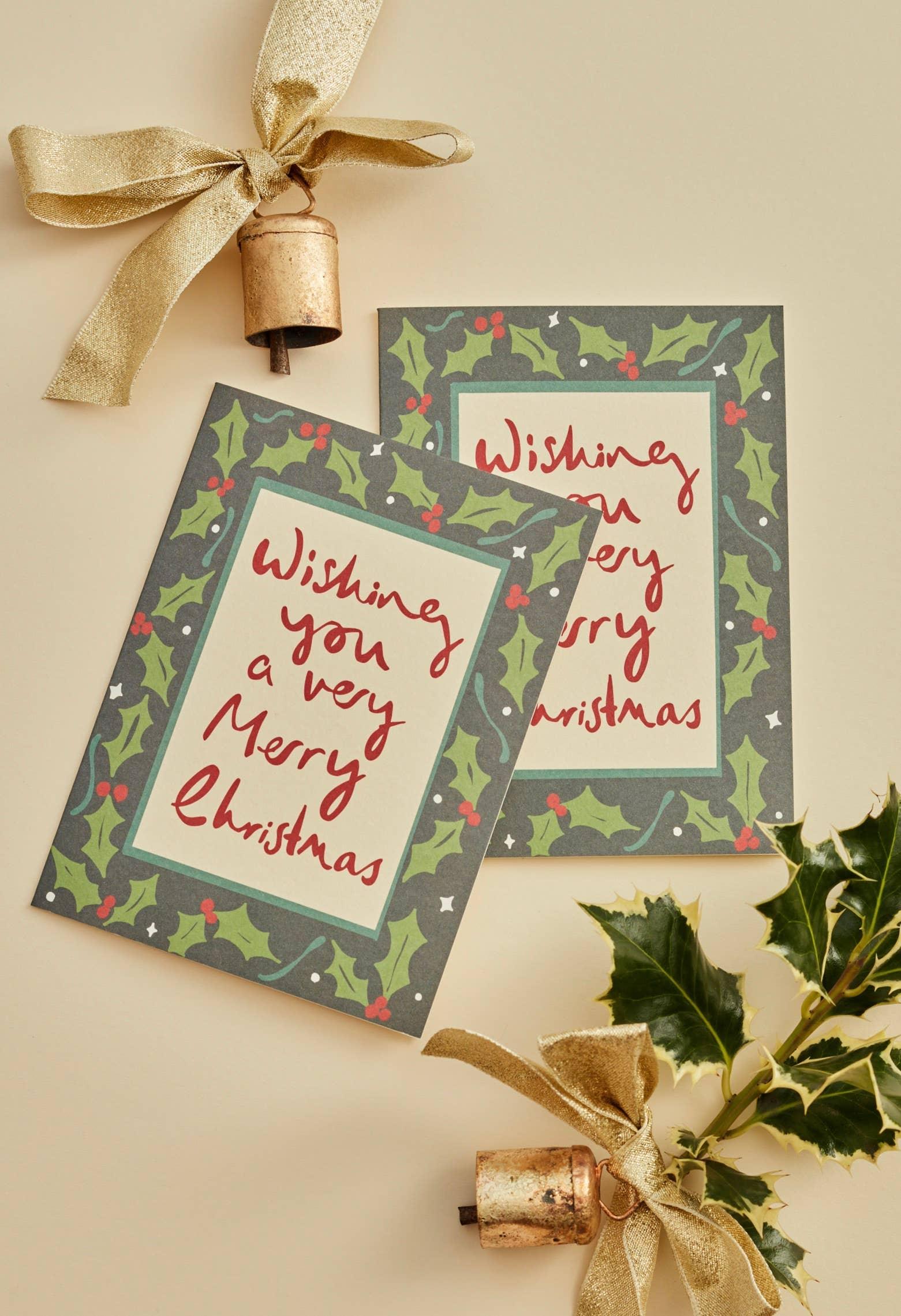 Hadley paper goods Merry Christmas card, recycled card, green holly border, gold bell, holly sprig