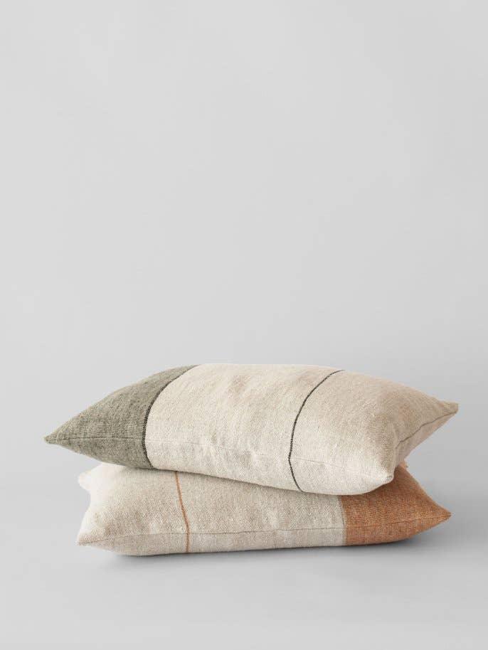 Hast woven linen pillows in beige, olive, and terracotta color blocks on neutral backdrop