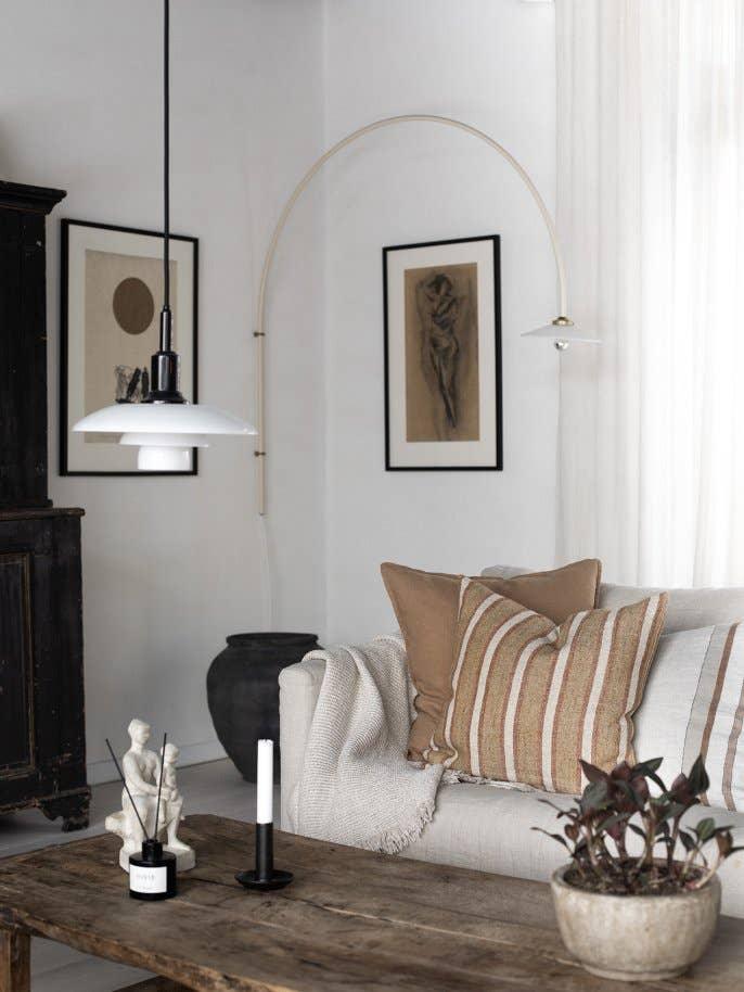 HAY pendant lamp, neutral linen sofa with brown striped cushions, wood coffee table, minimalist decor