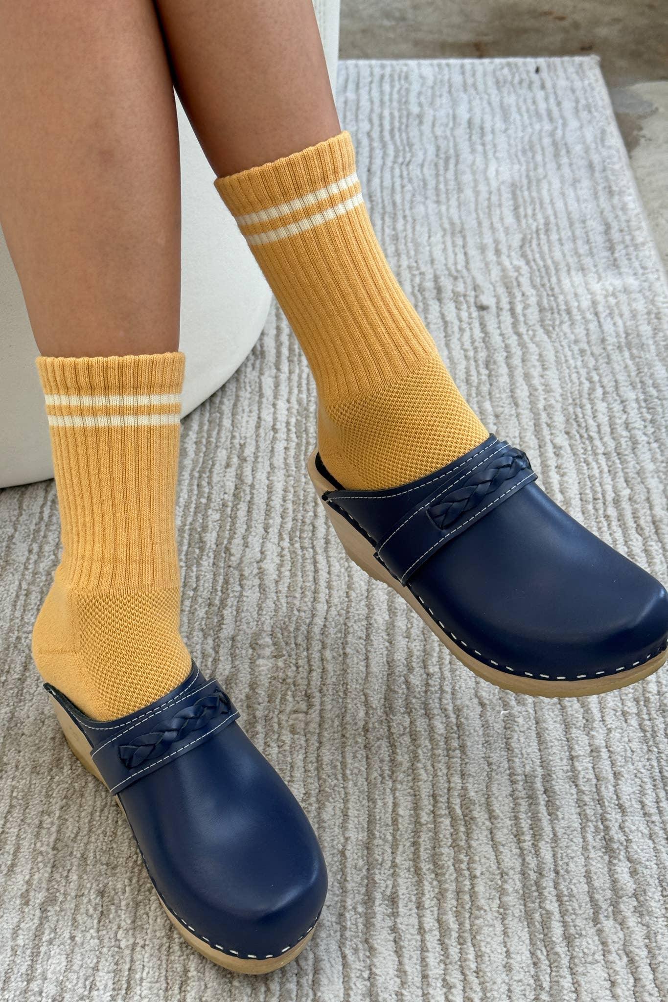 MIA navy leather clogs with braided strap, wood sole, and yellow striped socks