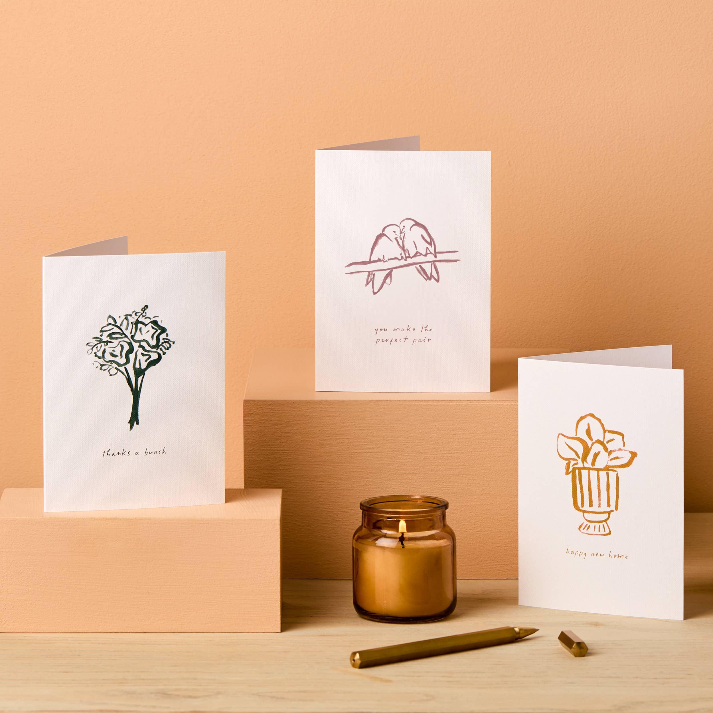 Ponderlily premium greeting cards, minimalist line art, white cardstock, gold pen, amber candle
